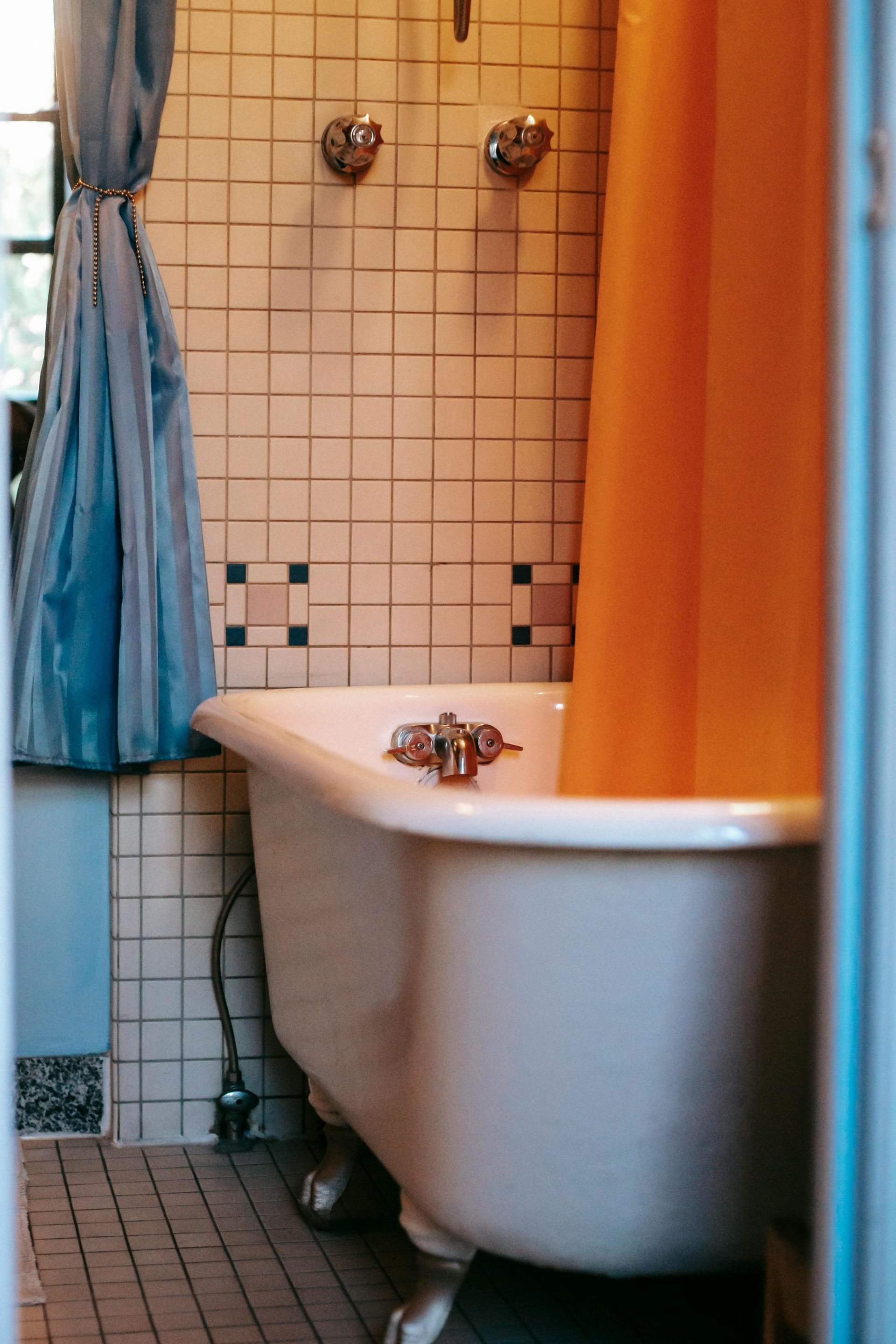 Clawfoot tub in retro tiled bathroom, pre-conversion for modern shower.