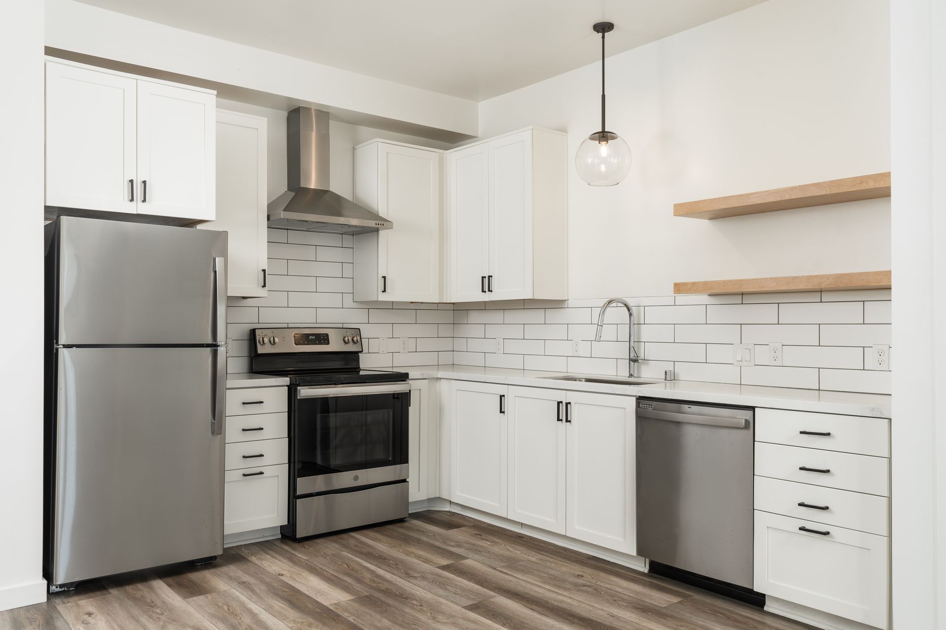 A kitchen with stainless steel appliances and white cabinets.