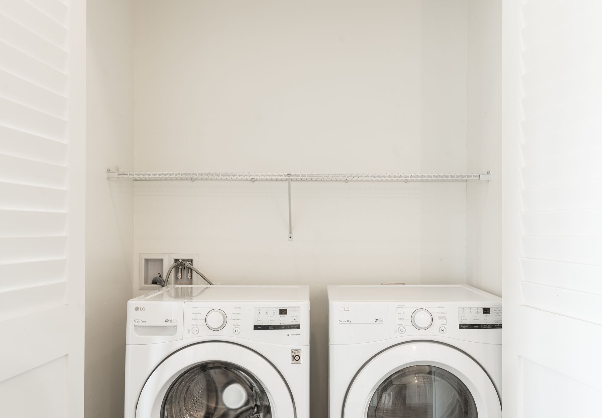 There are two washers and dryers in the laundry room.