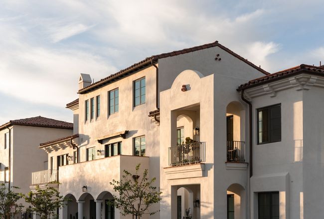 A large white house with a balcony and a tiled roof.