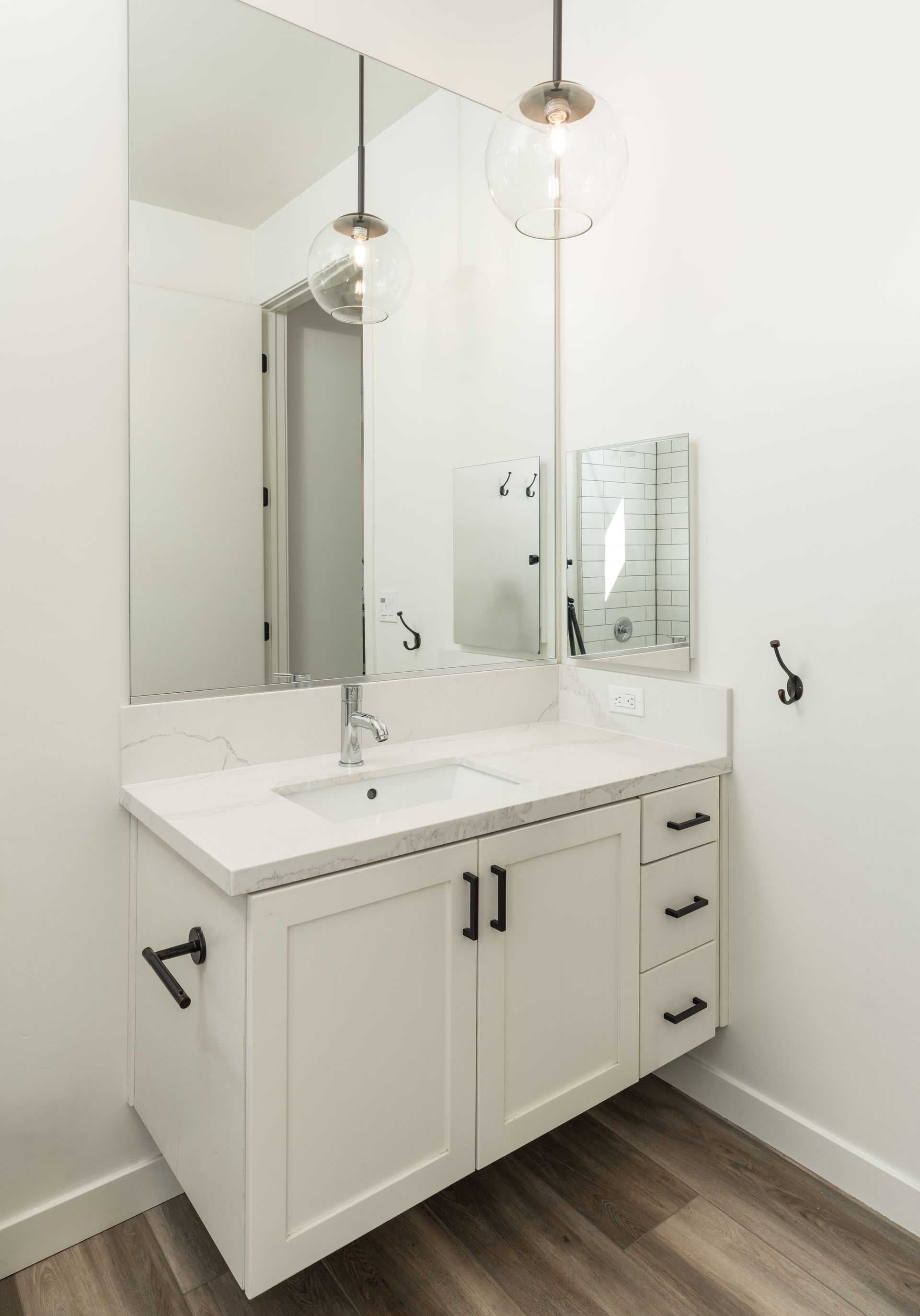 A bathroom with a sink , mirror and cabinets.