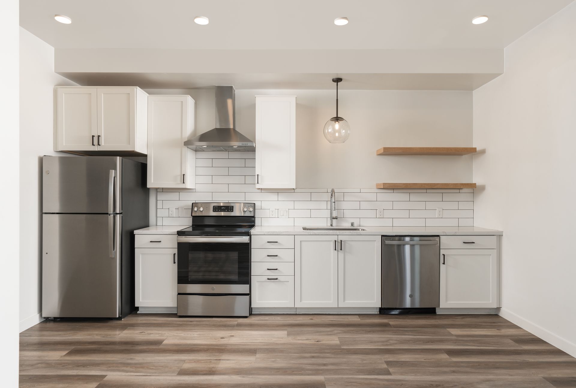 A kitchen with stainless steel appliances and white cabinets