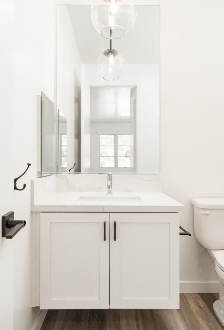 A bathroom with a sink , toilet and mirror.