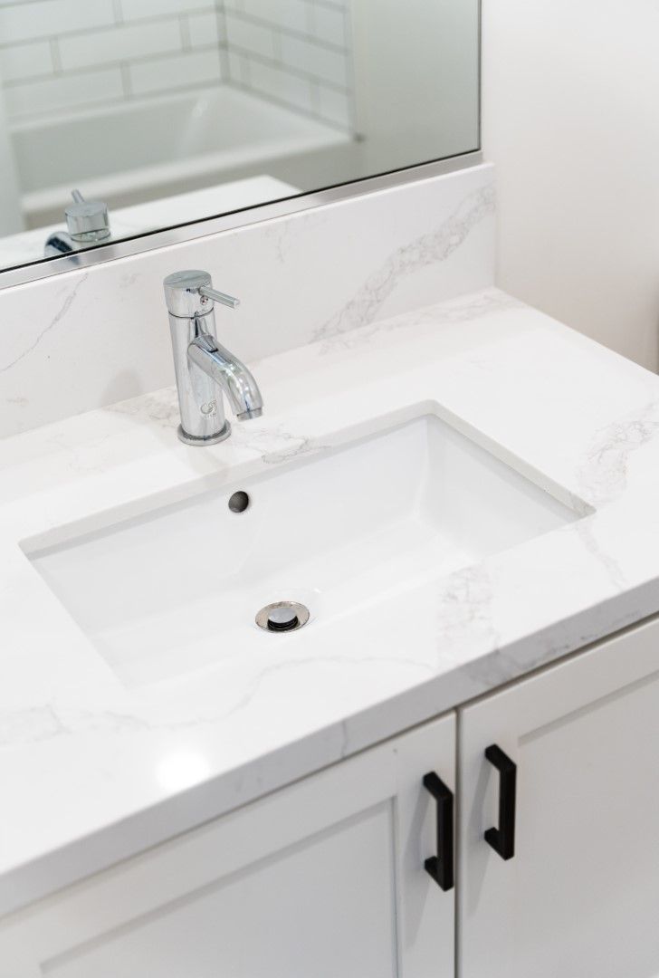 A bathroom sink with a faucet and a mirror