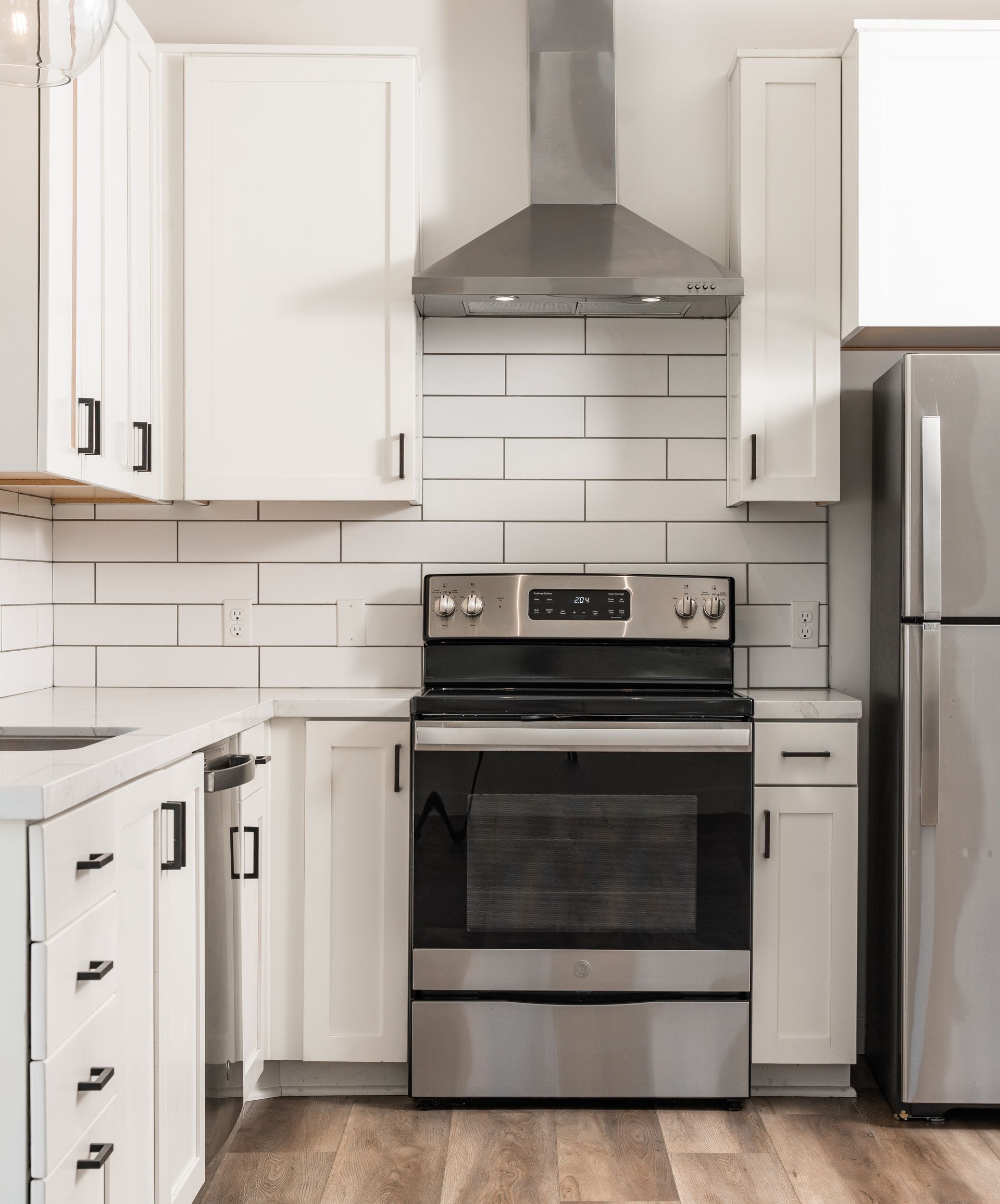 A kitchen with stainless steel appliances and white cabinets