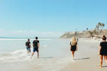 A group of people are walking on a beach.