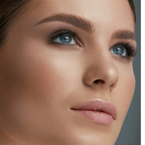 Frau mit blauen Augen, vollen Augenbrauen, geschminkt, Blick nach oben.