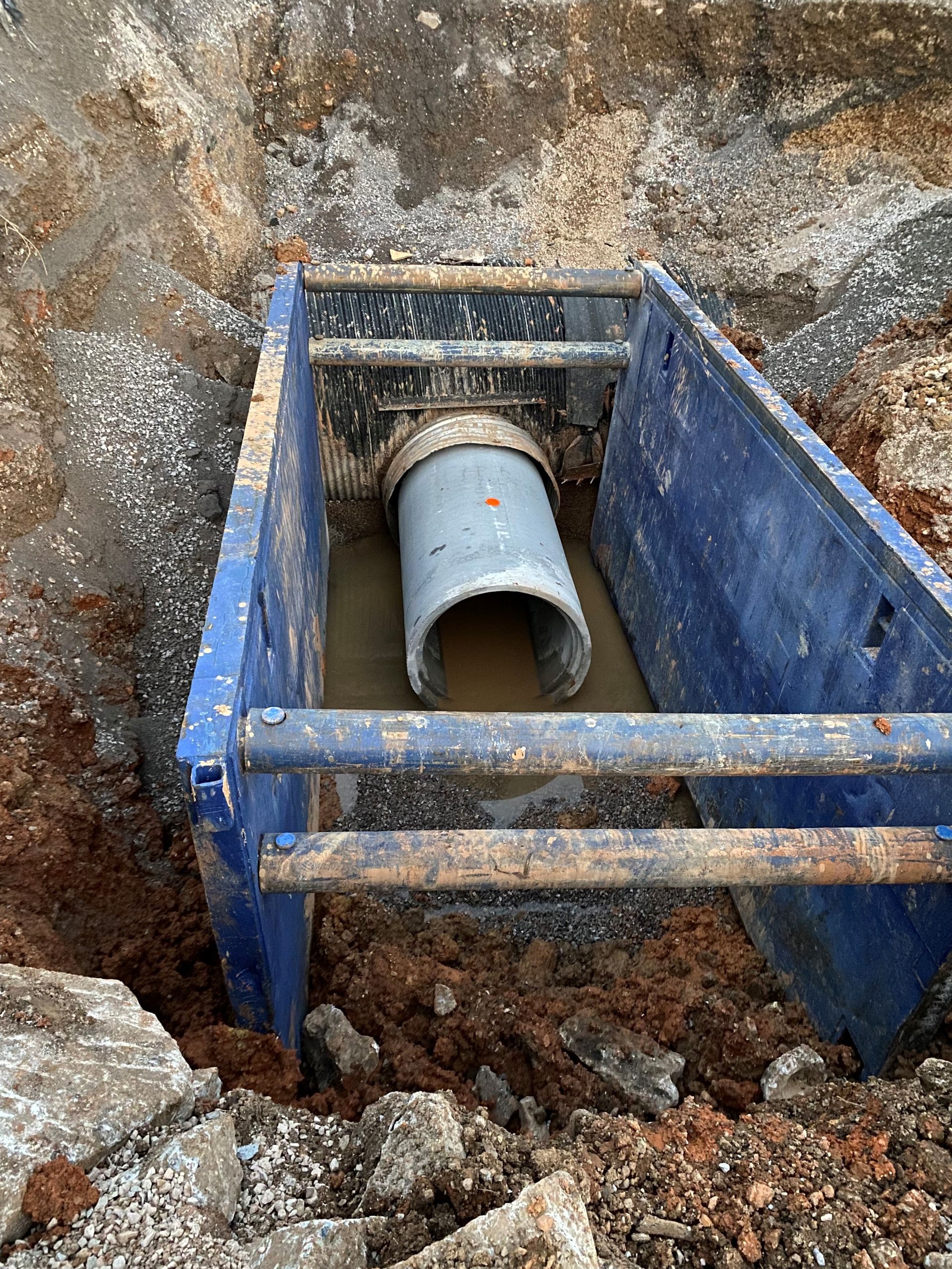 A large pipe is being installed in a hole in the ground.