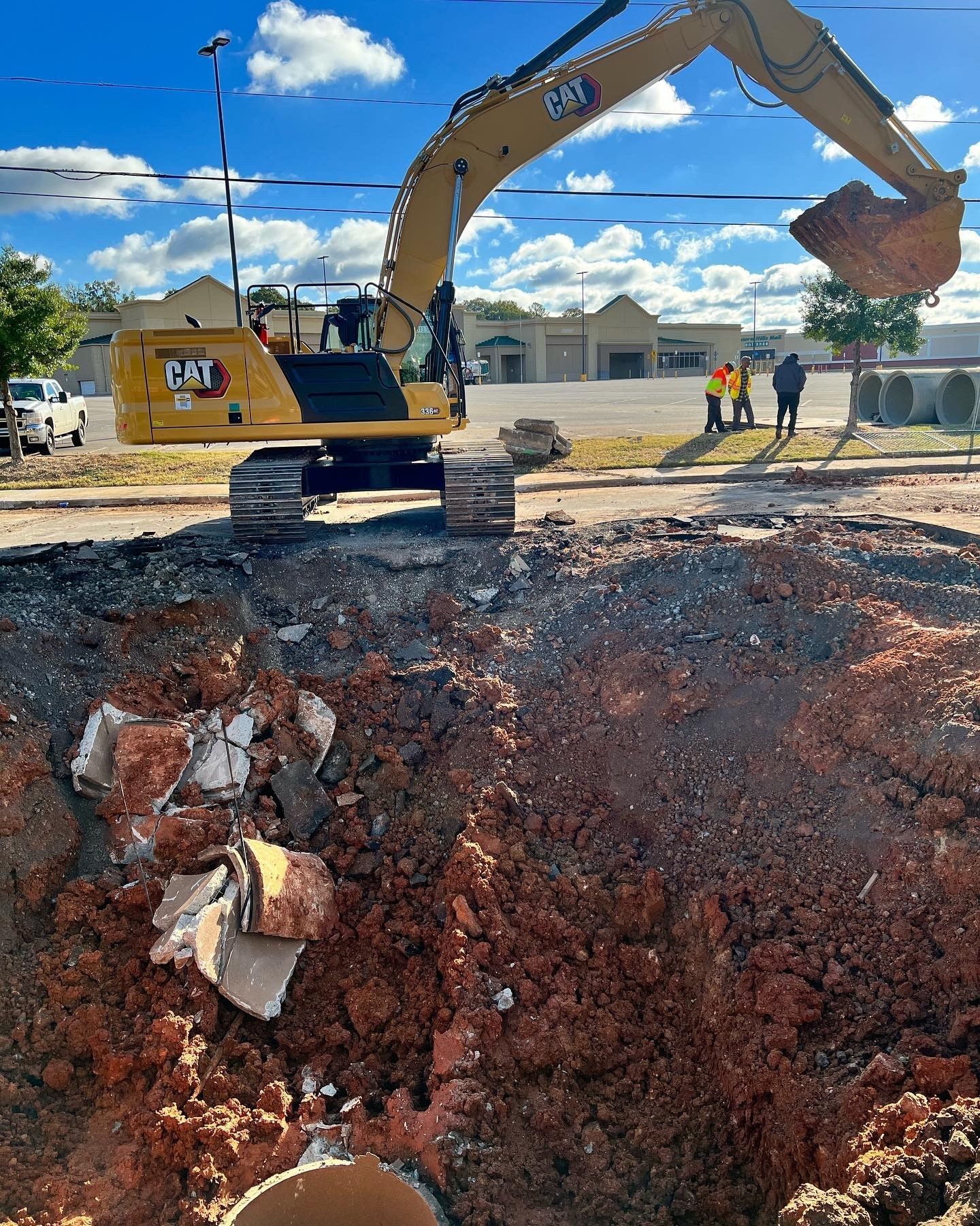 A cat excavator is digging a hole in the ground