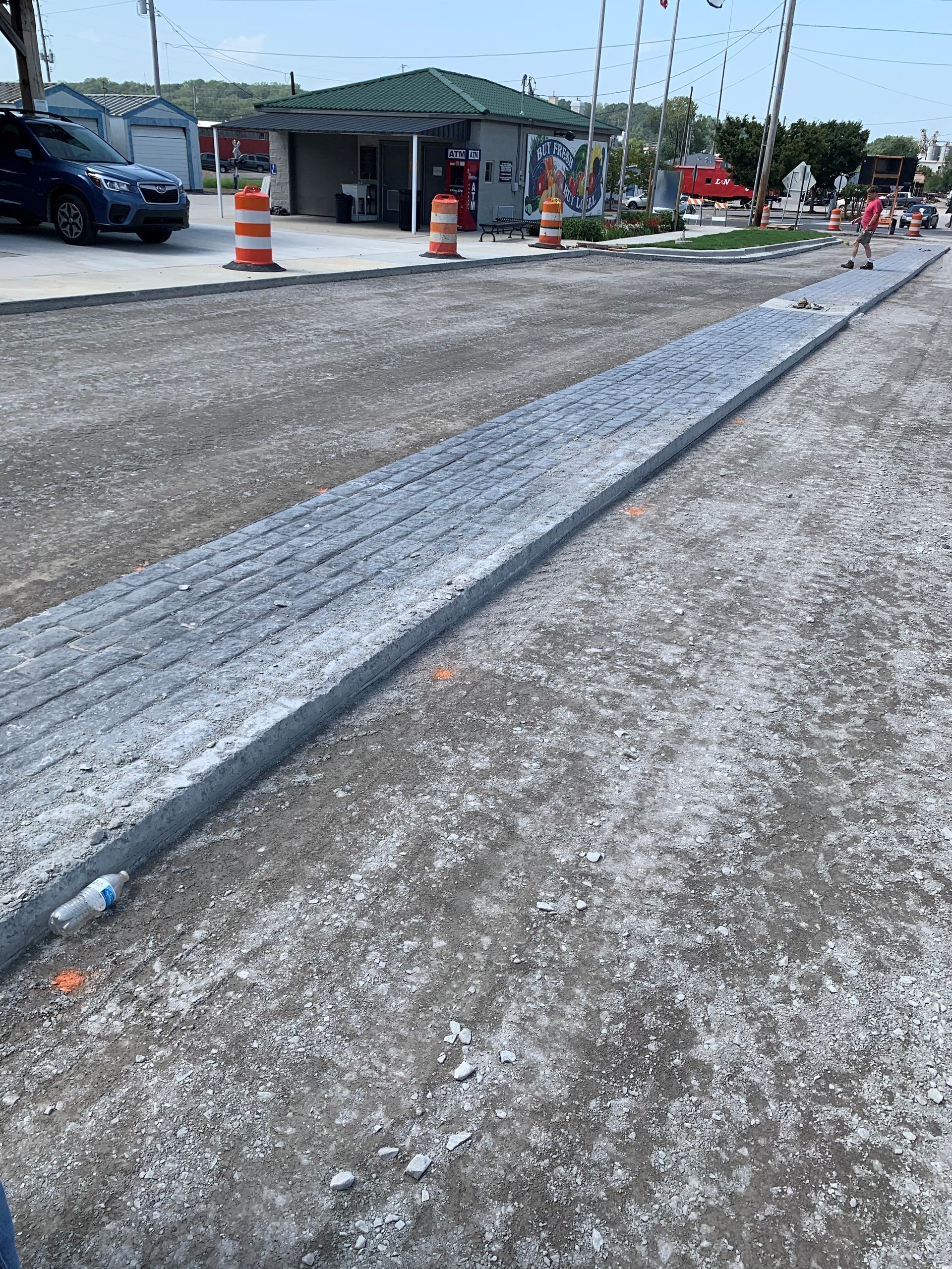 A concrete curb is being installed on the side of a road.