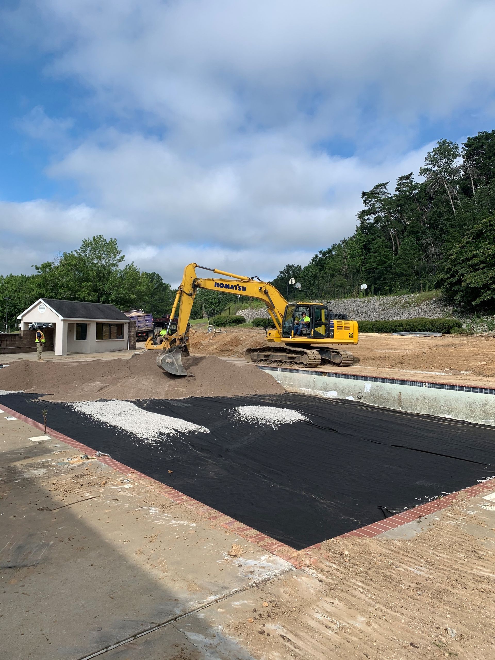 A yellow excavator is working on a construction site.