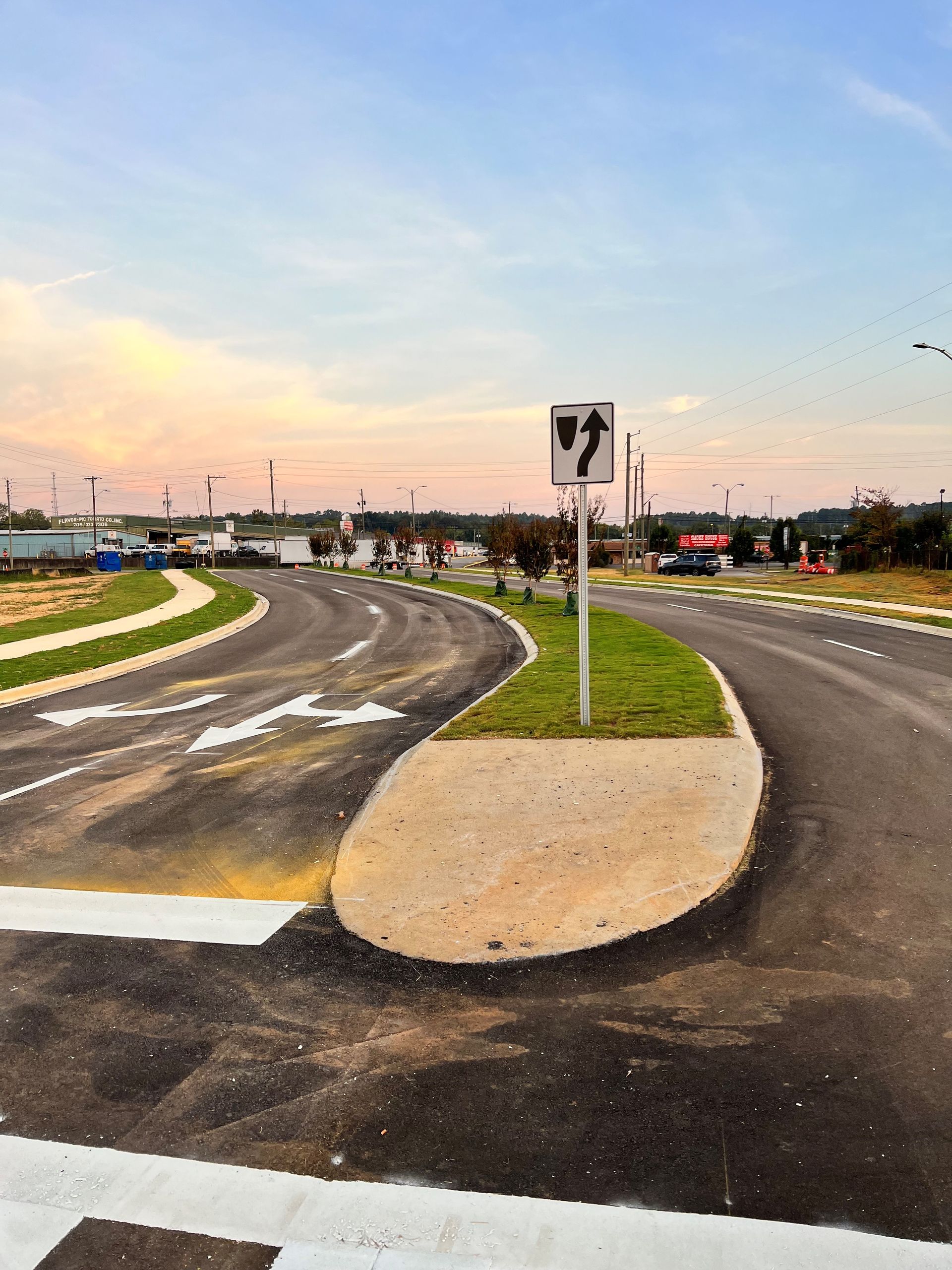 A road with a sign that says ' turn left ' on it