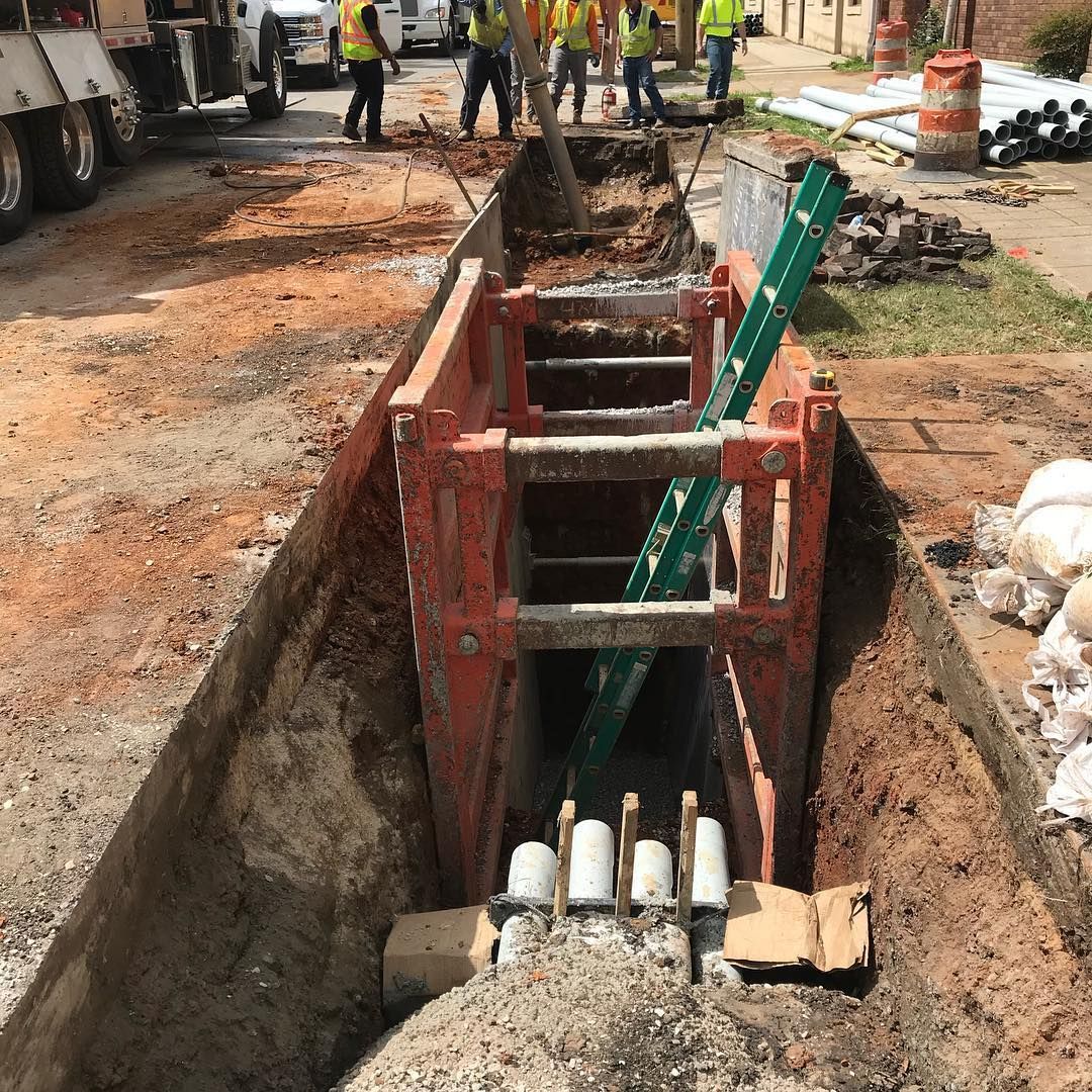 Worker Digging and Installing Pipes — Birmingham, AL — Southeastern Sealcoating, Inc.