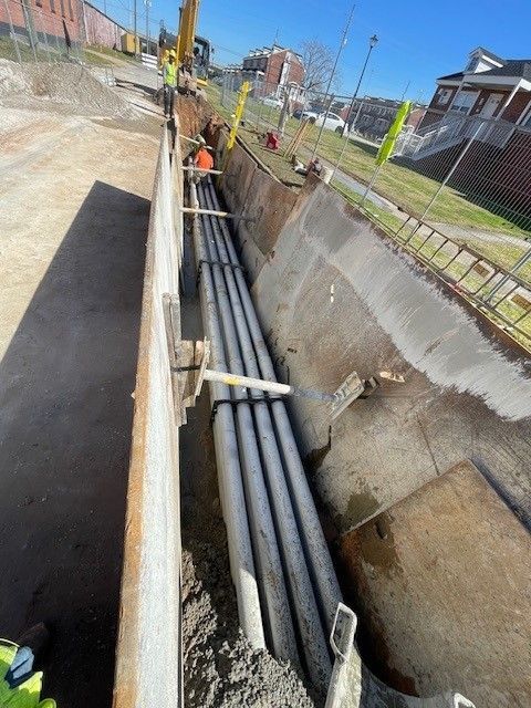 A bunch of pipes are being installed in a trench.
