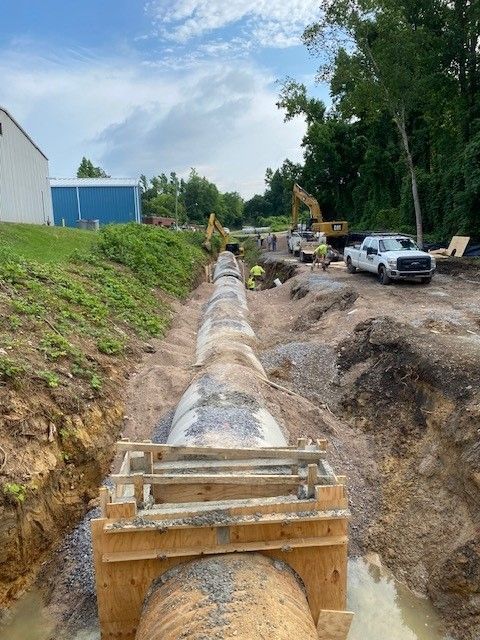 A large pipe is being installed in a trench.