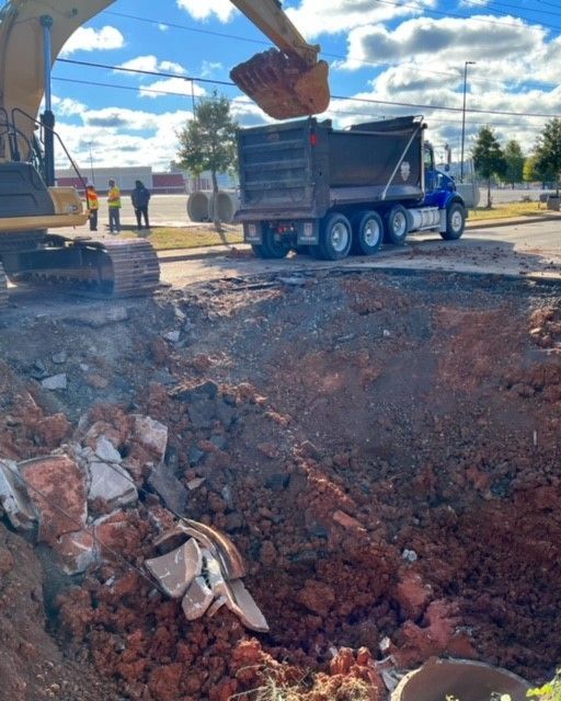 An excavator is loading dirt into a dump truck