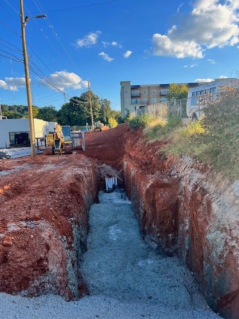A large hole in the ground with a building in the background.