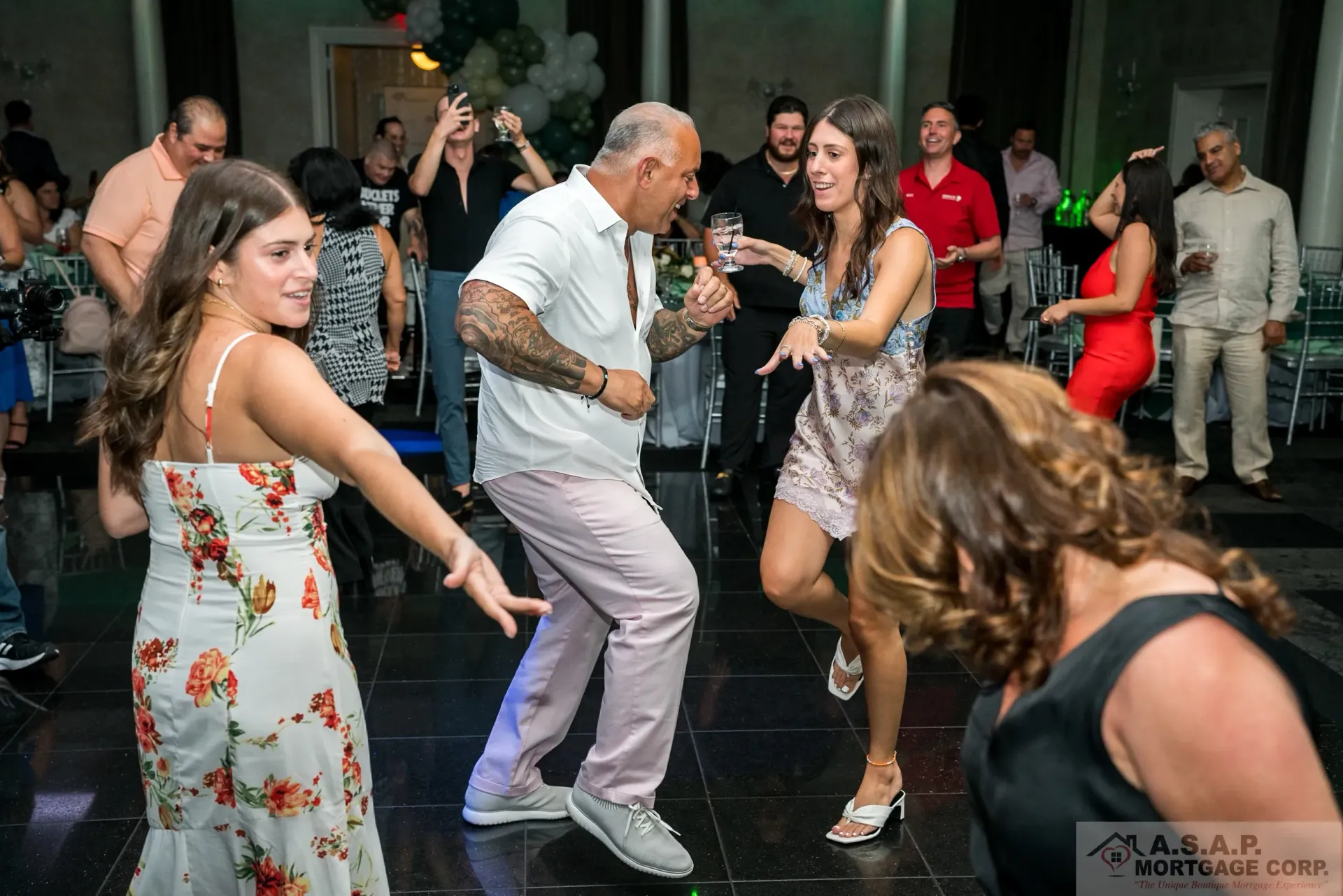 A group of people are dancing on a dance floor at a party.