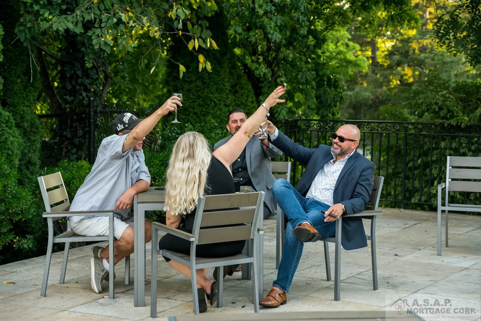 A group of people are sitting at a table with their arms in the air.