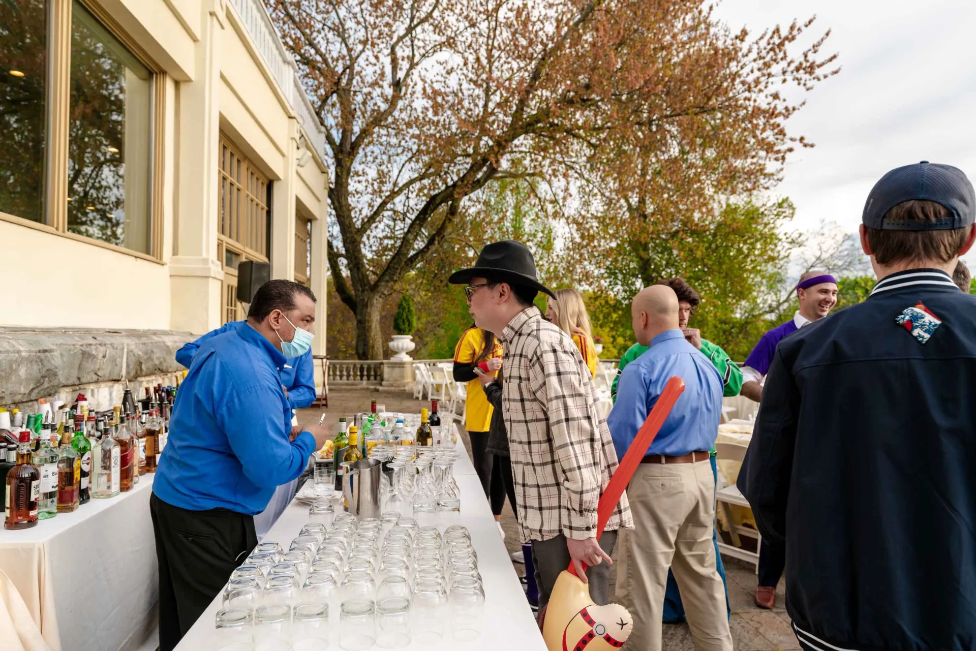 A group of people are standing around a bar.