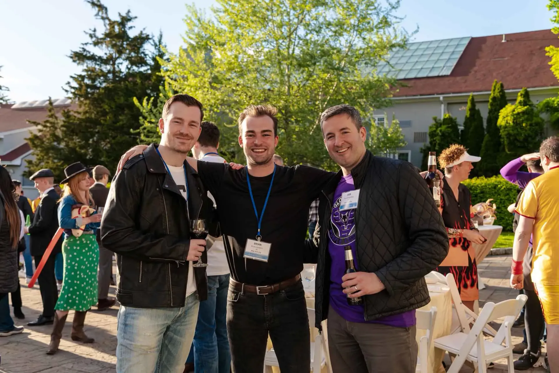 Three men are posing for a picture in front of a crowd of people.