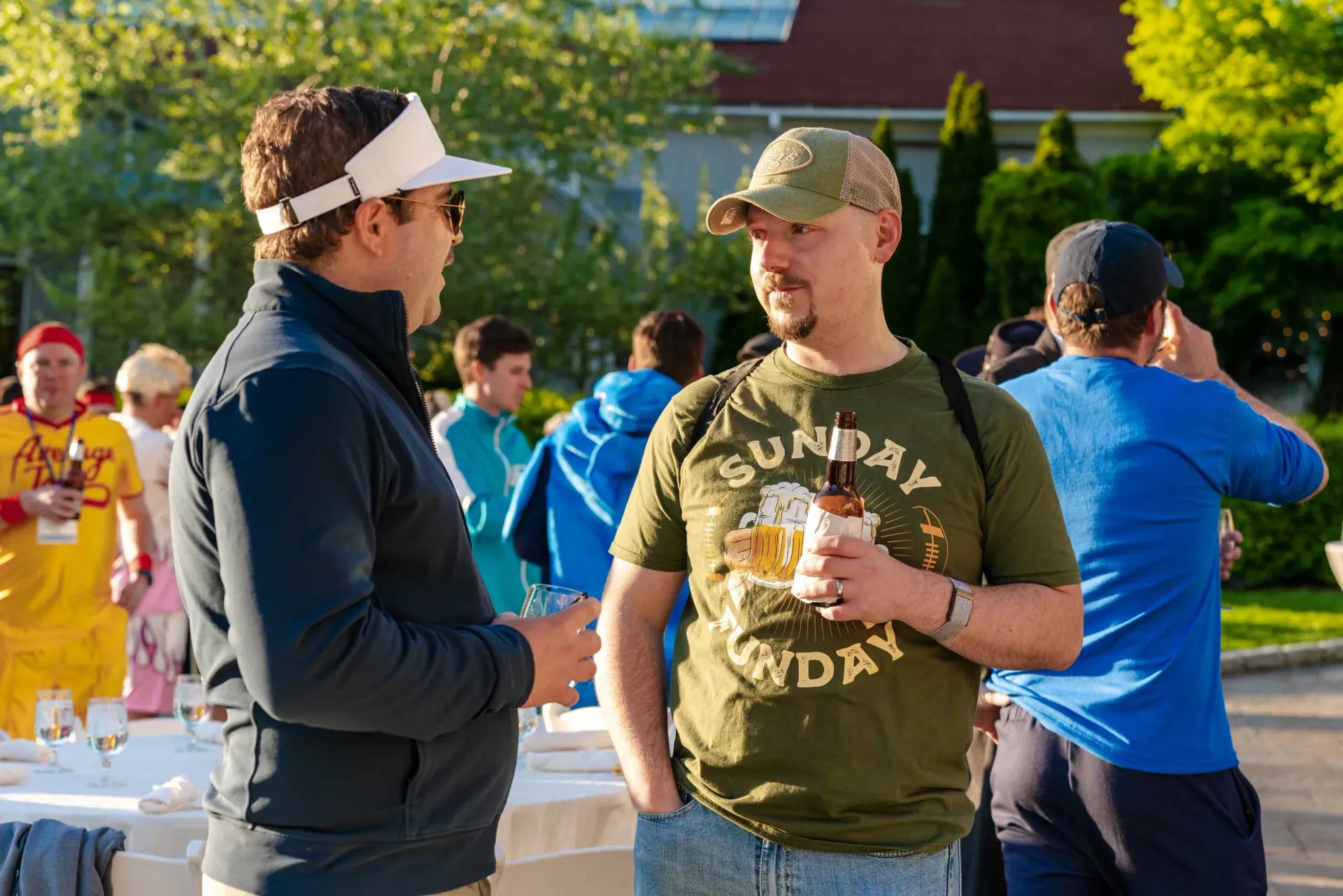 A man wearing a sunday shirt is talking to another man