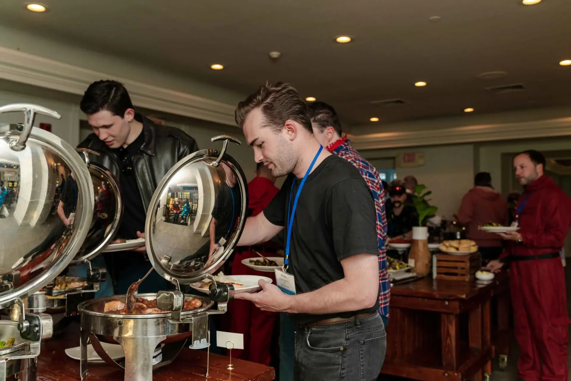 A man is standing in front of a buffet line.