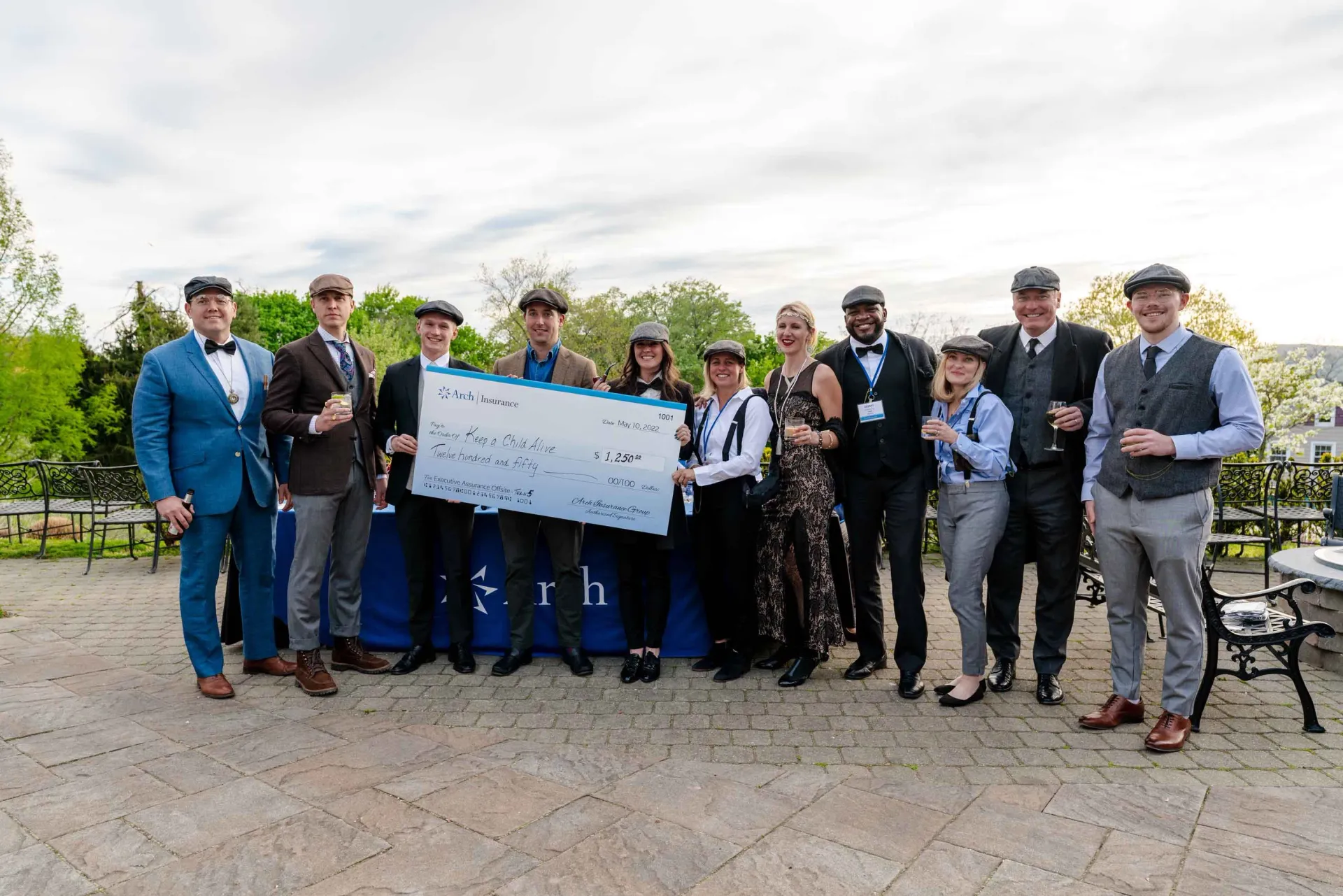 A group of people standing next to each other holding a large check.
