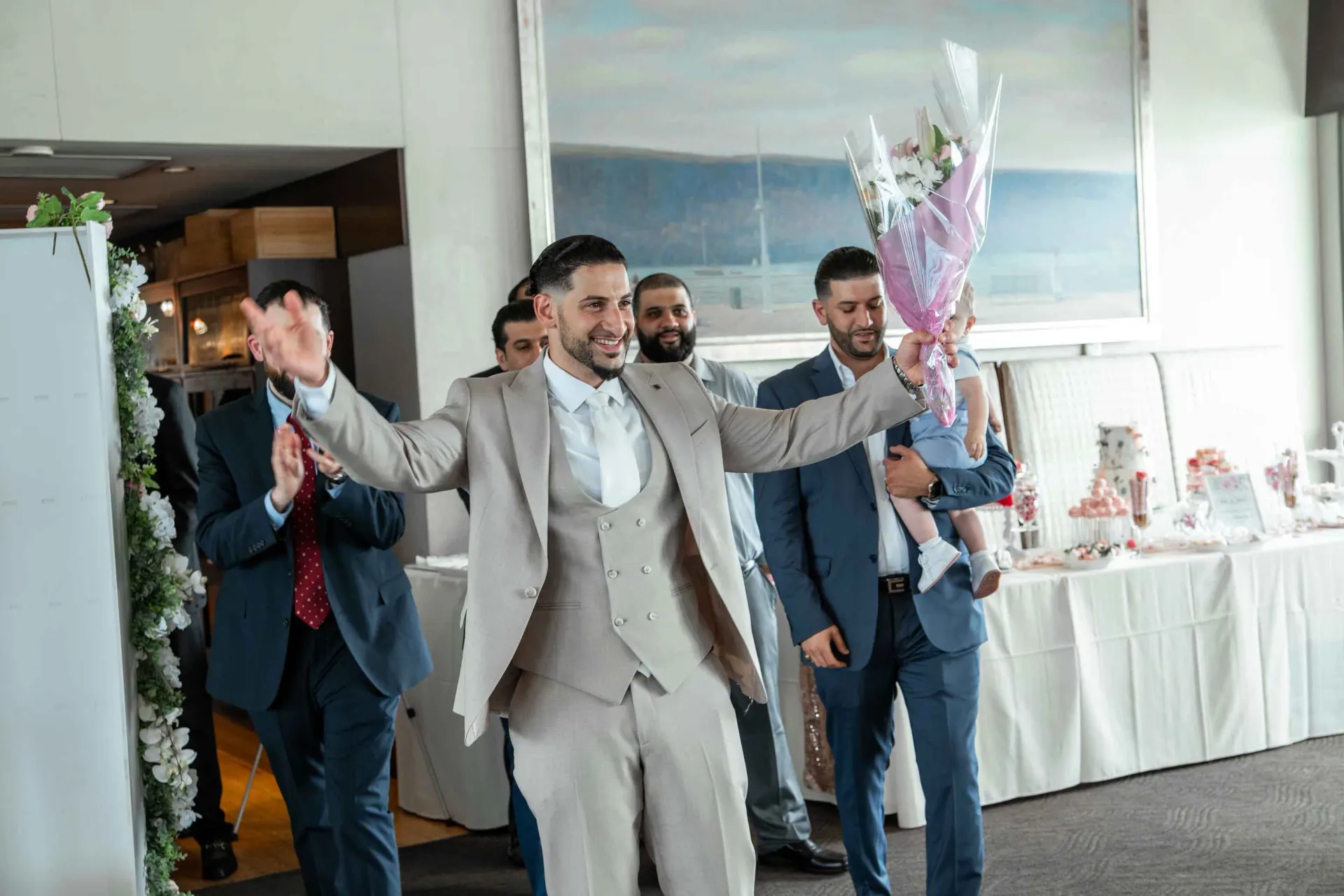 A man in a suit is holding a bouquet of flowers.