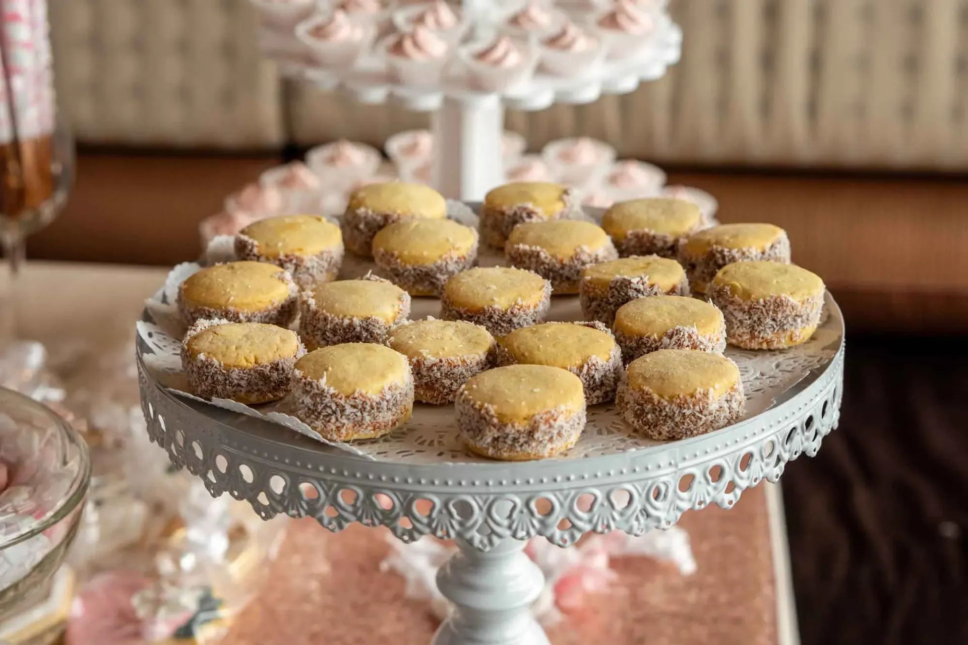 A white cake stand filled with cookies on a table.
