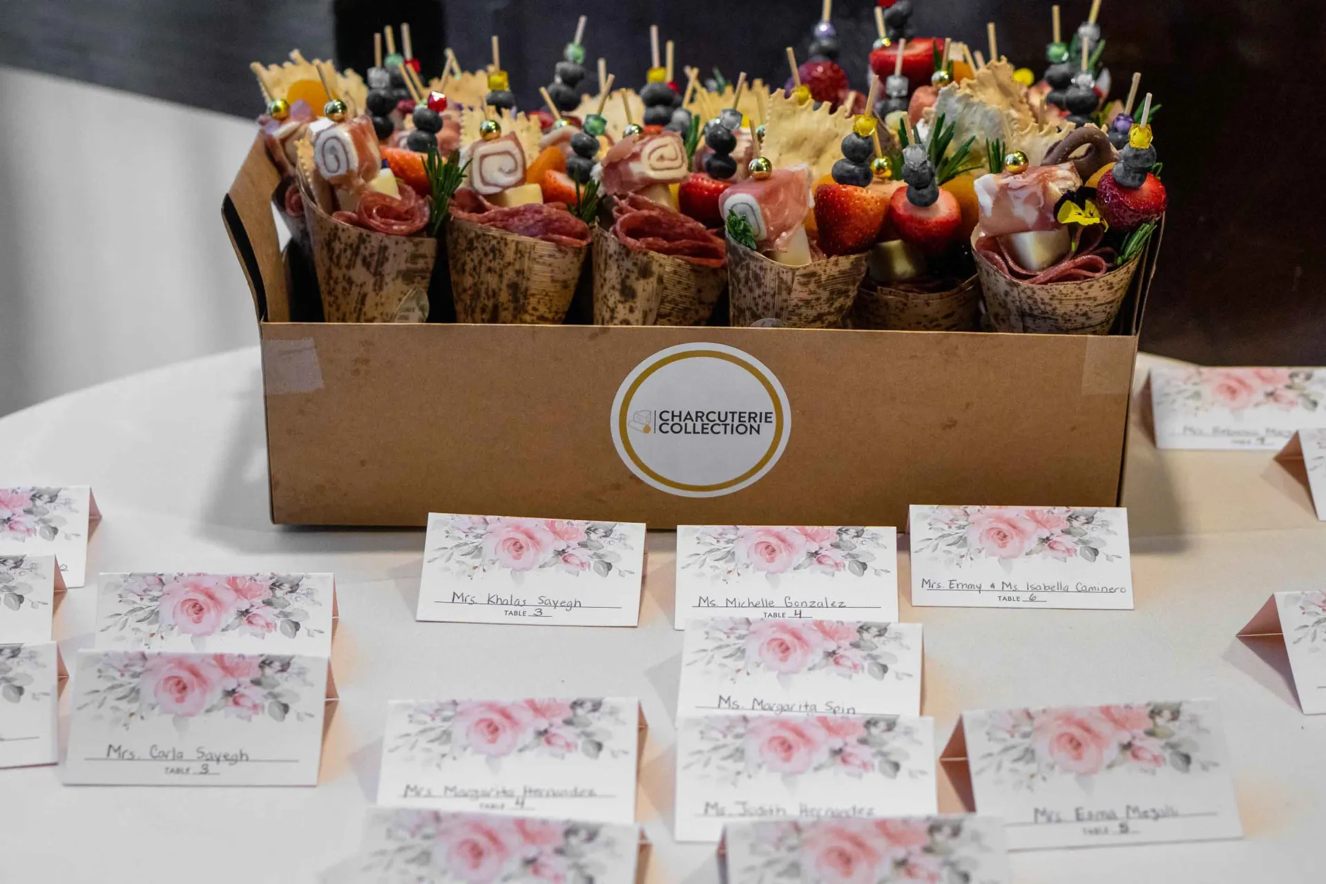 A table with a box of food and place cards on it.