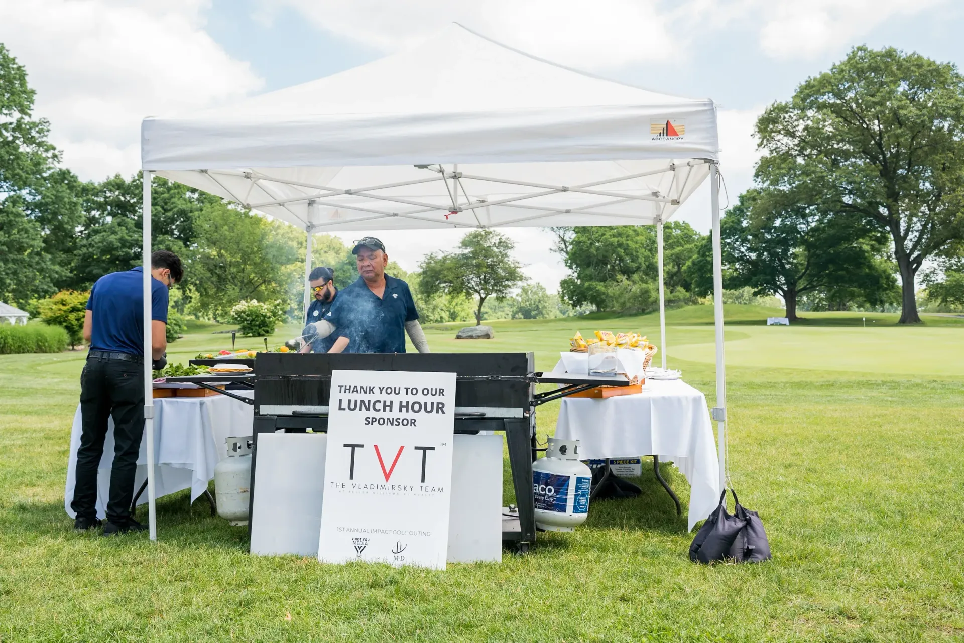 A man is standing in front of a tent in a park.