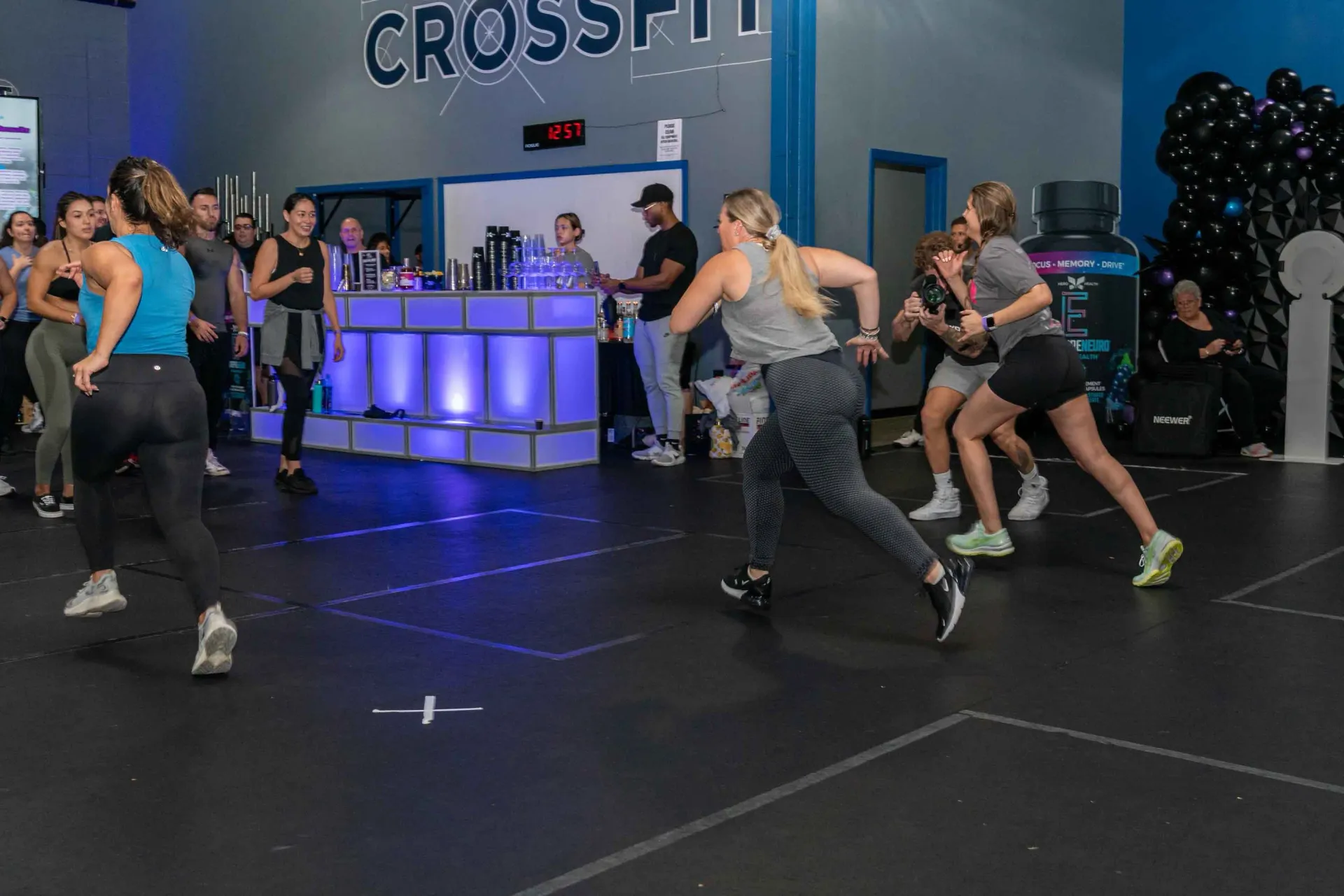 A group of people are dancing in a gym.