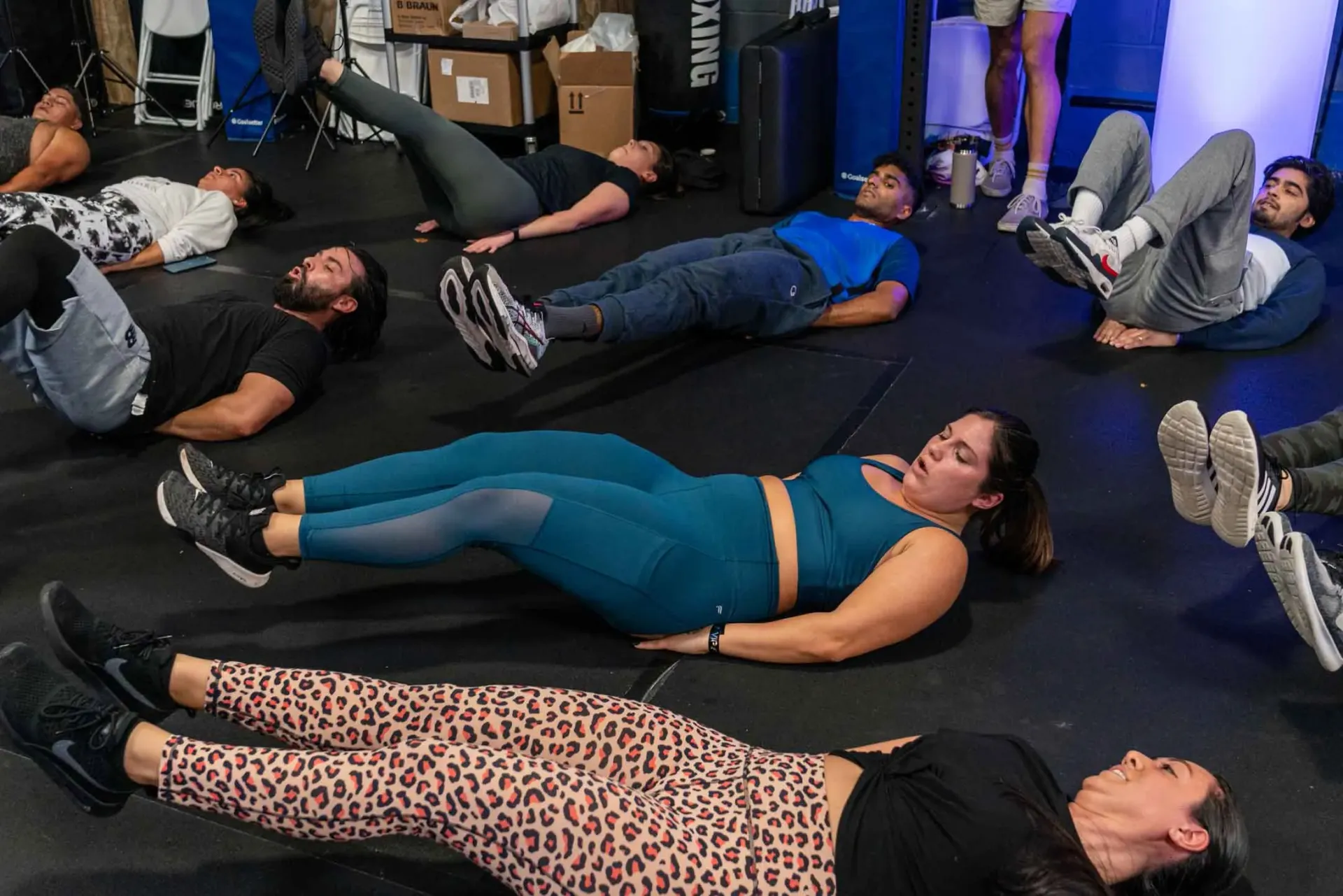 A group of people are laying on the floor doing exercises.