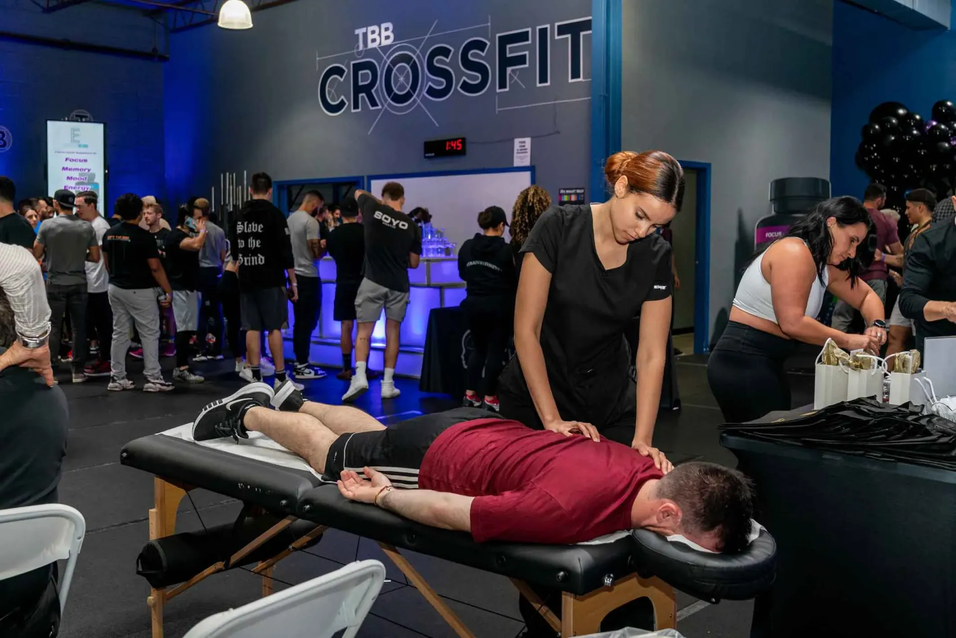 A woman is giving a man a massage in a gym.