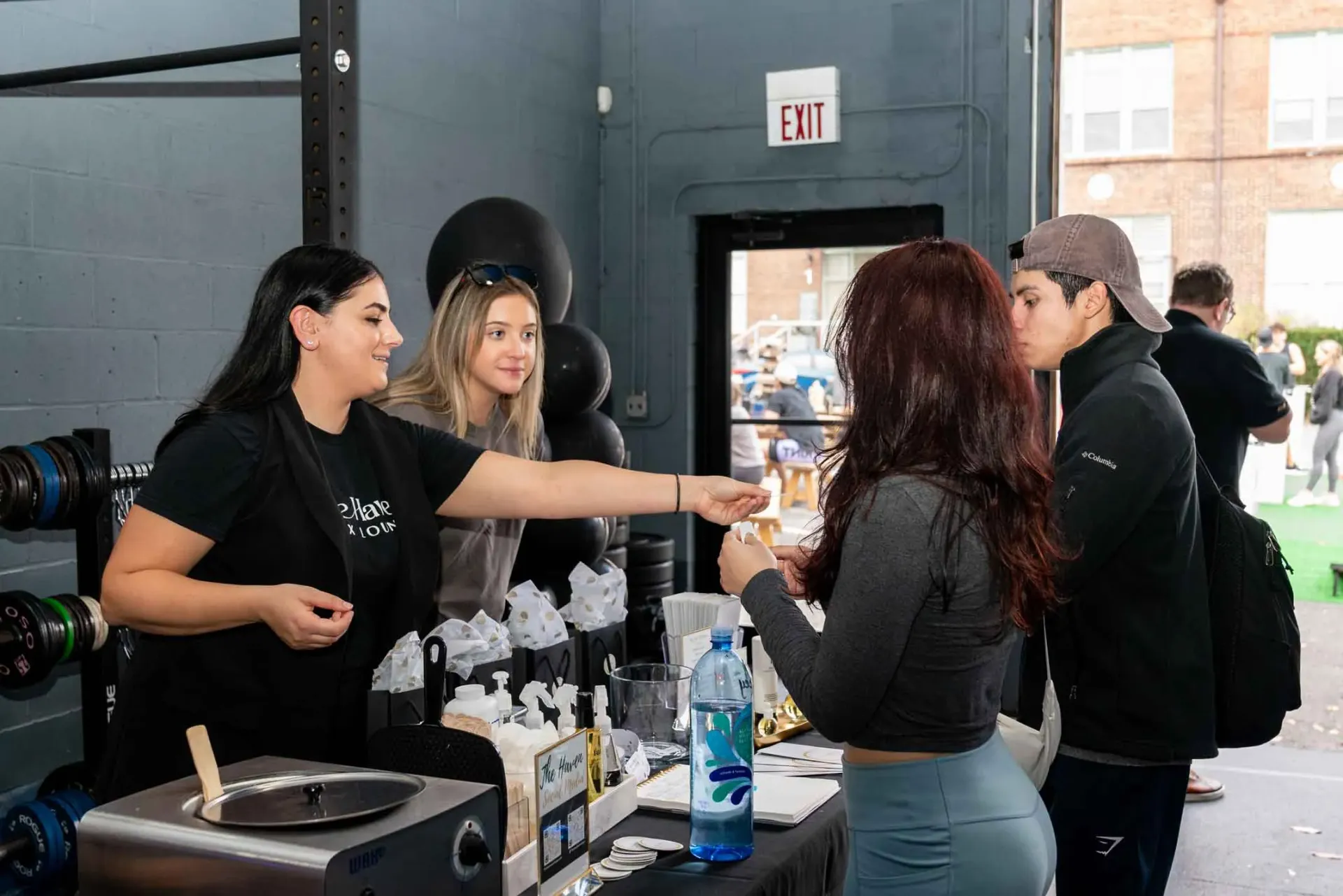A group of people are standing around a table in a gym.