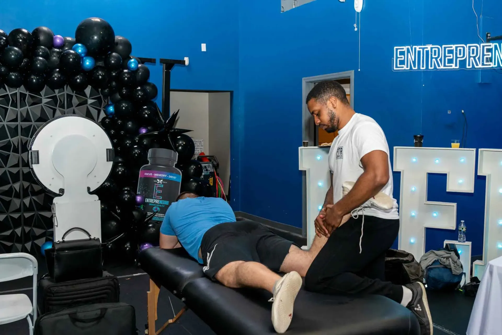A man is stretching another man 's leg on a table.