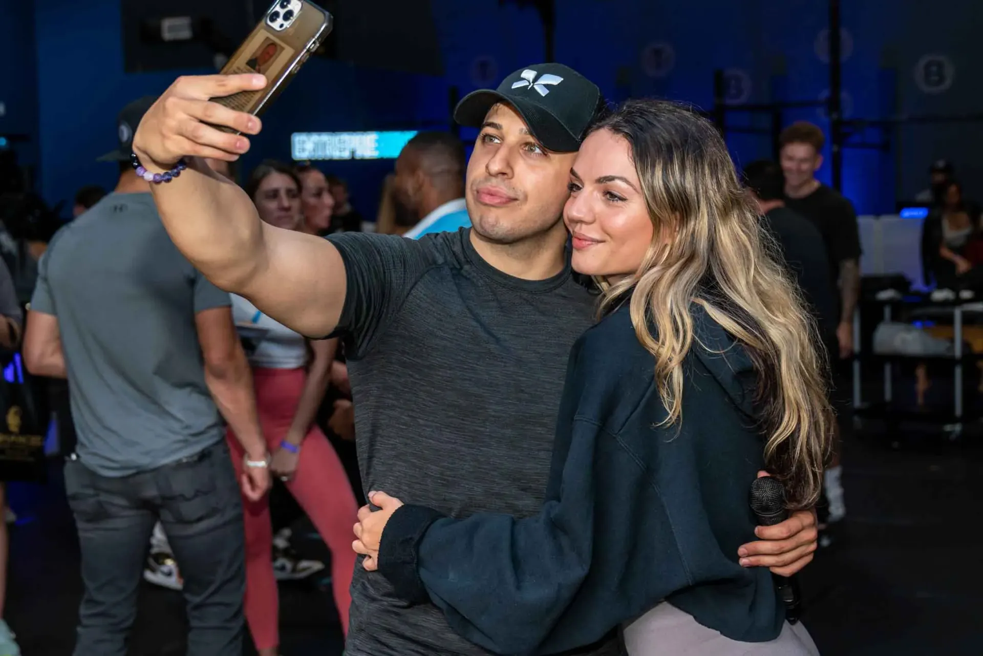 A man is taking a selfie with a woman at a party.