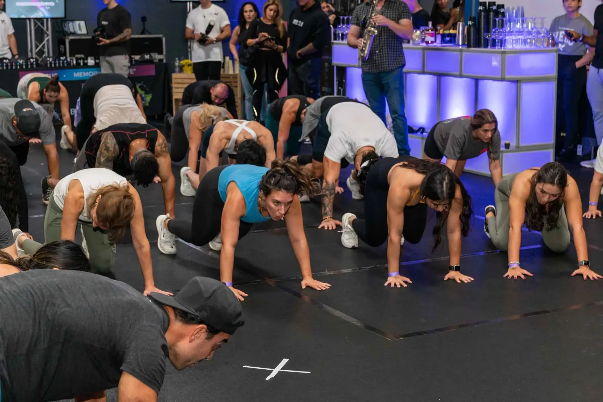 A group of people are doing push ups in a gym.