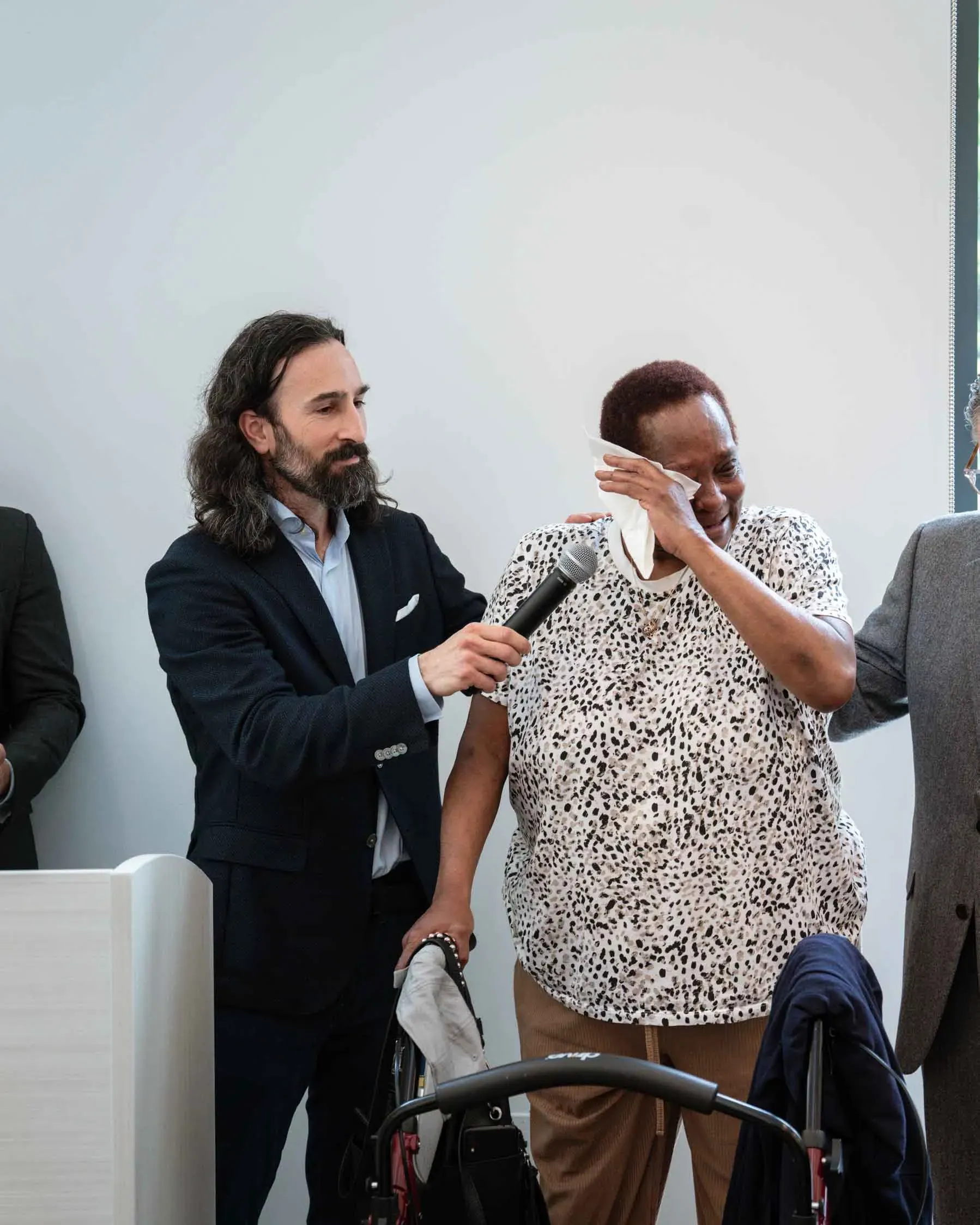 A man is holding a microphone next to a woman in a wheelchair.