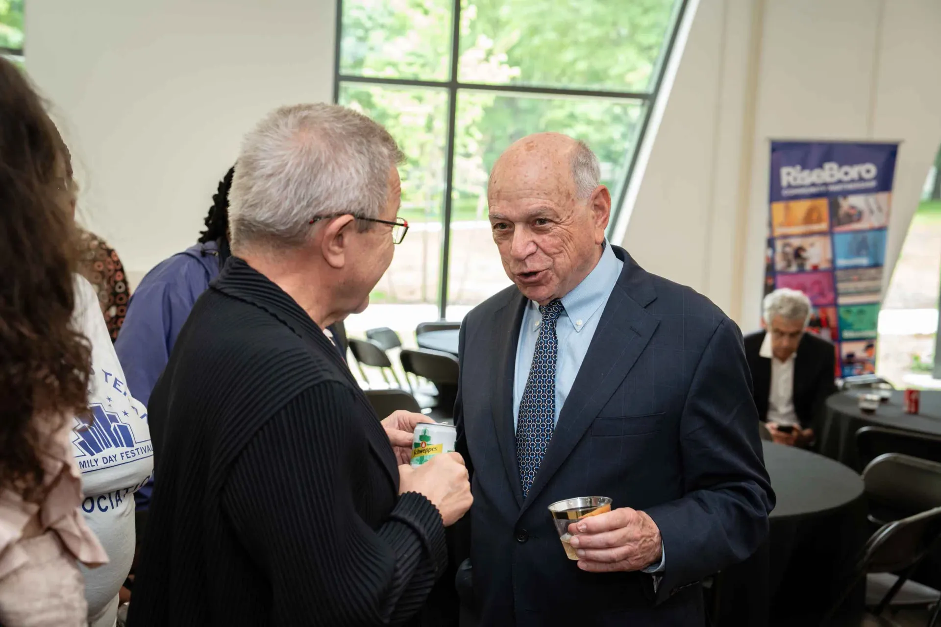 Two men in suits are talking to each other in a room.