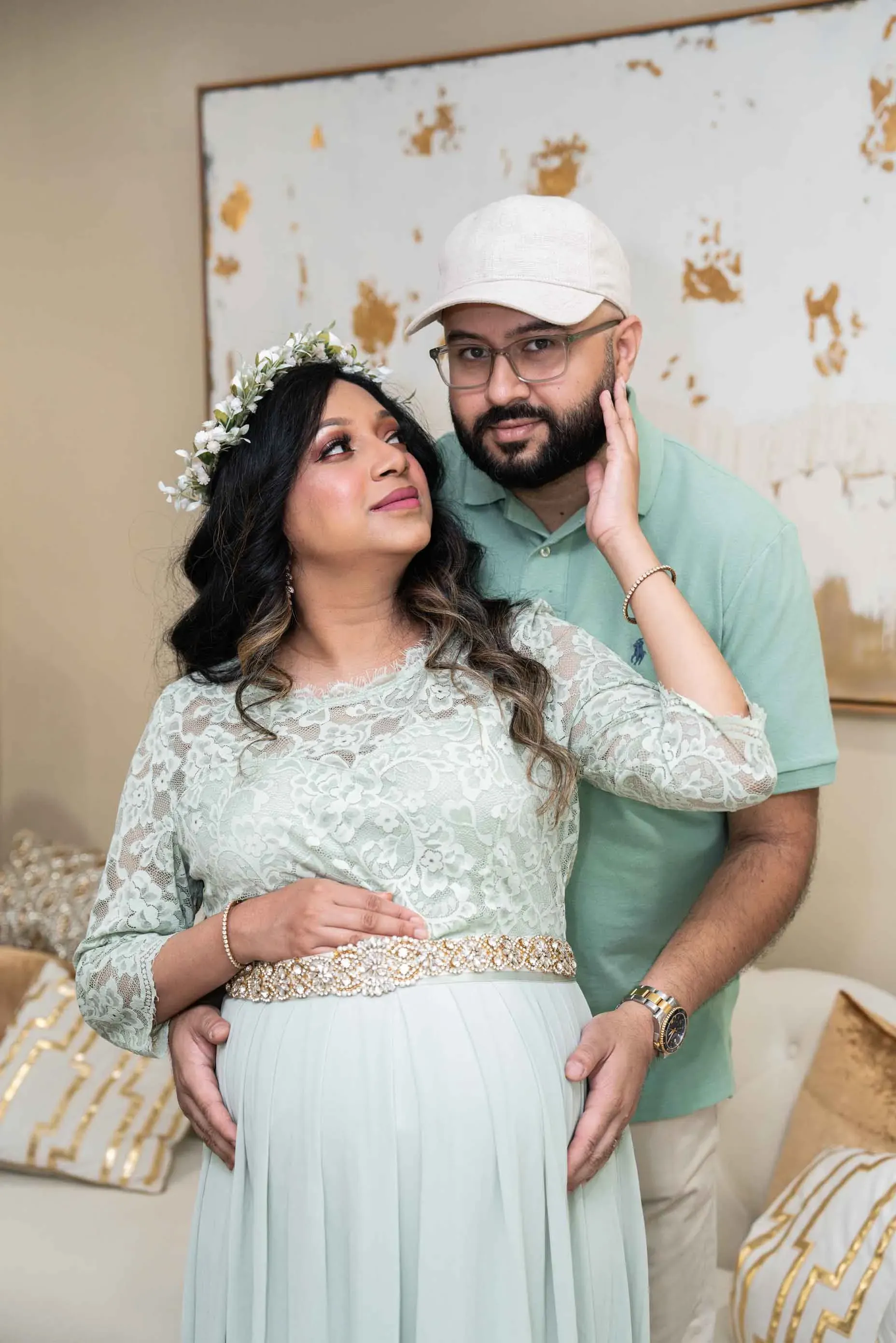A man and a pregnant woman are standing next to each other in a living room.