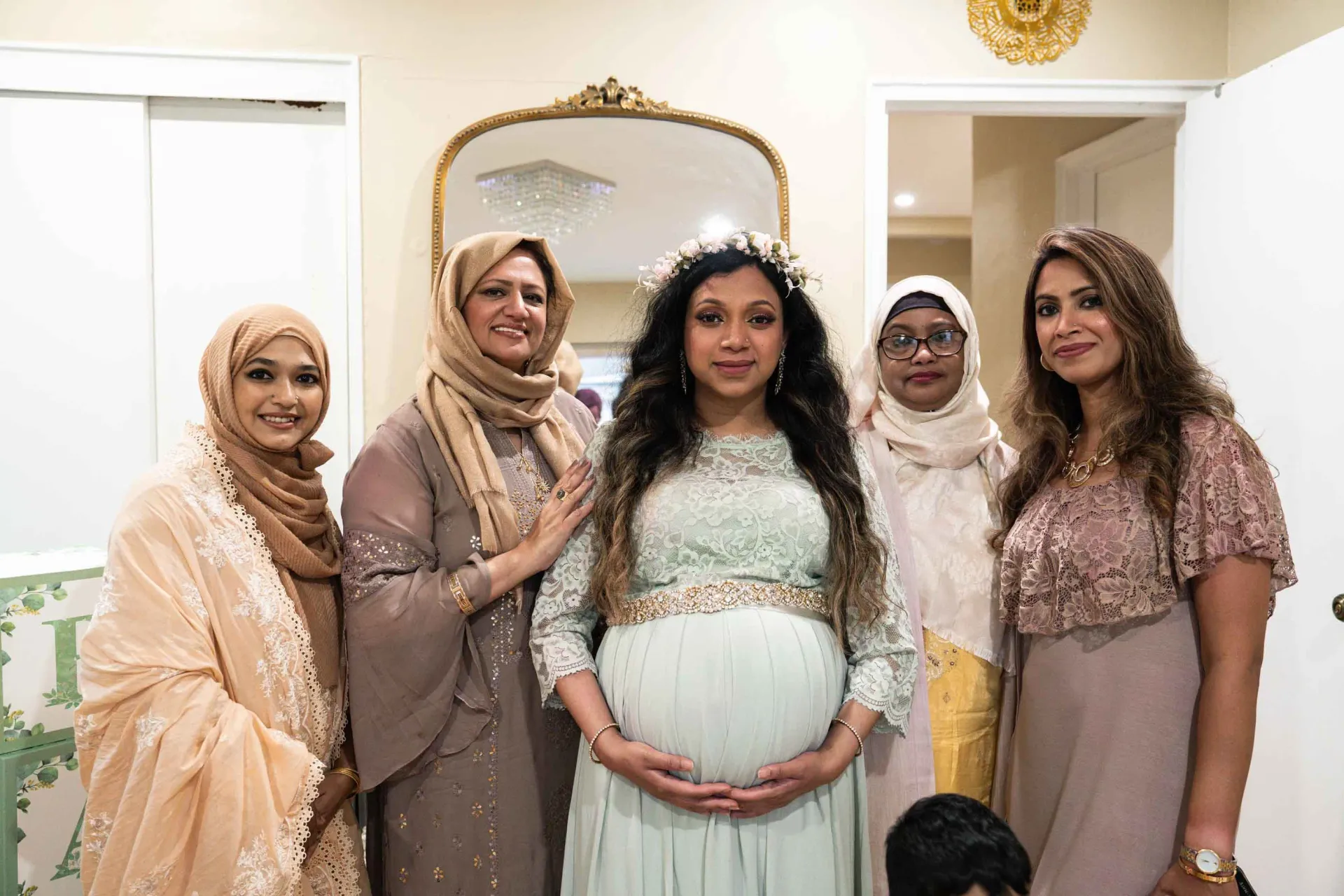 A group of women are posing for a picture with a pregnant woman.