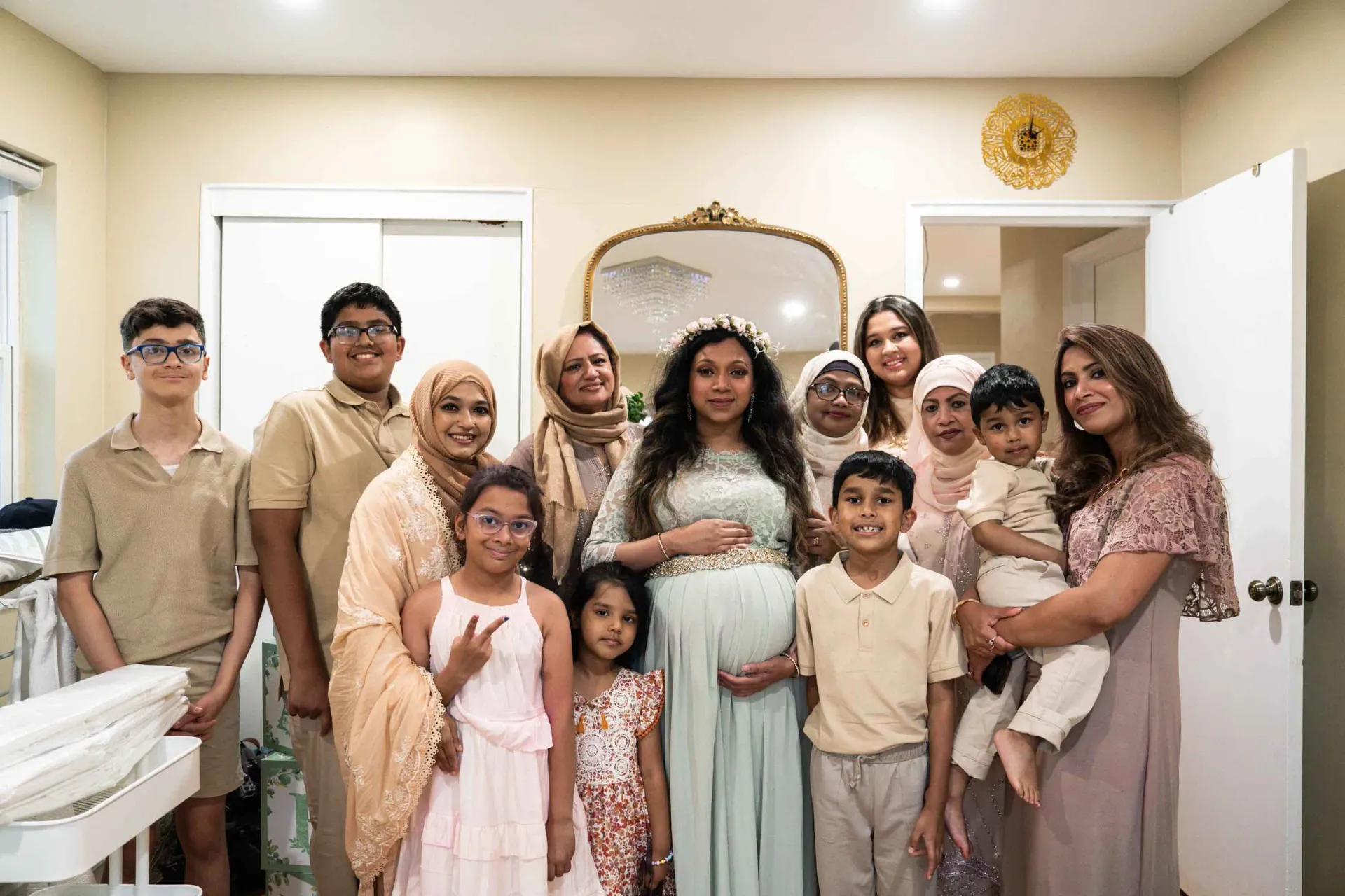 A group of people are posing for a picture with a pregnant woman.