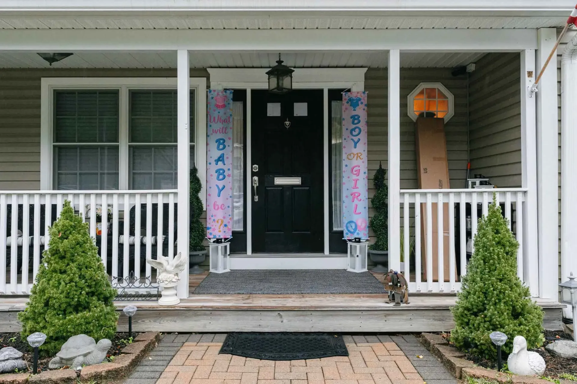 The front of a house with a porch and a black door.
