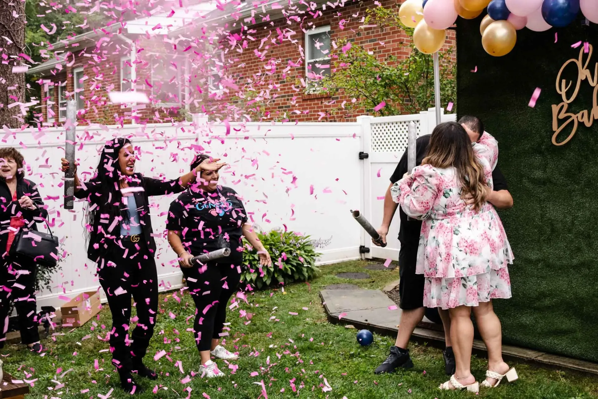 A group of people are throwing confetti at a gender reveal party.