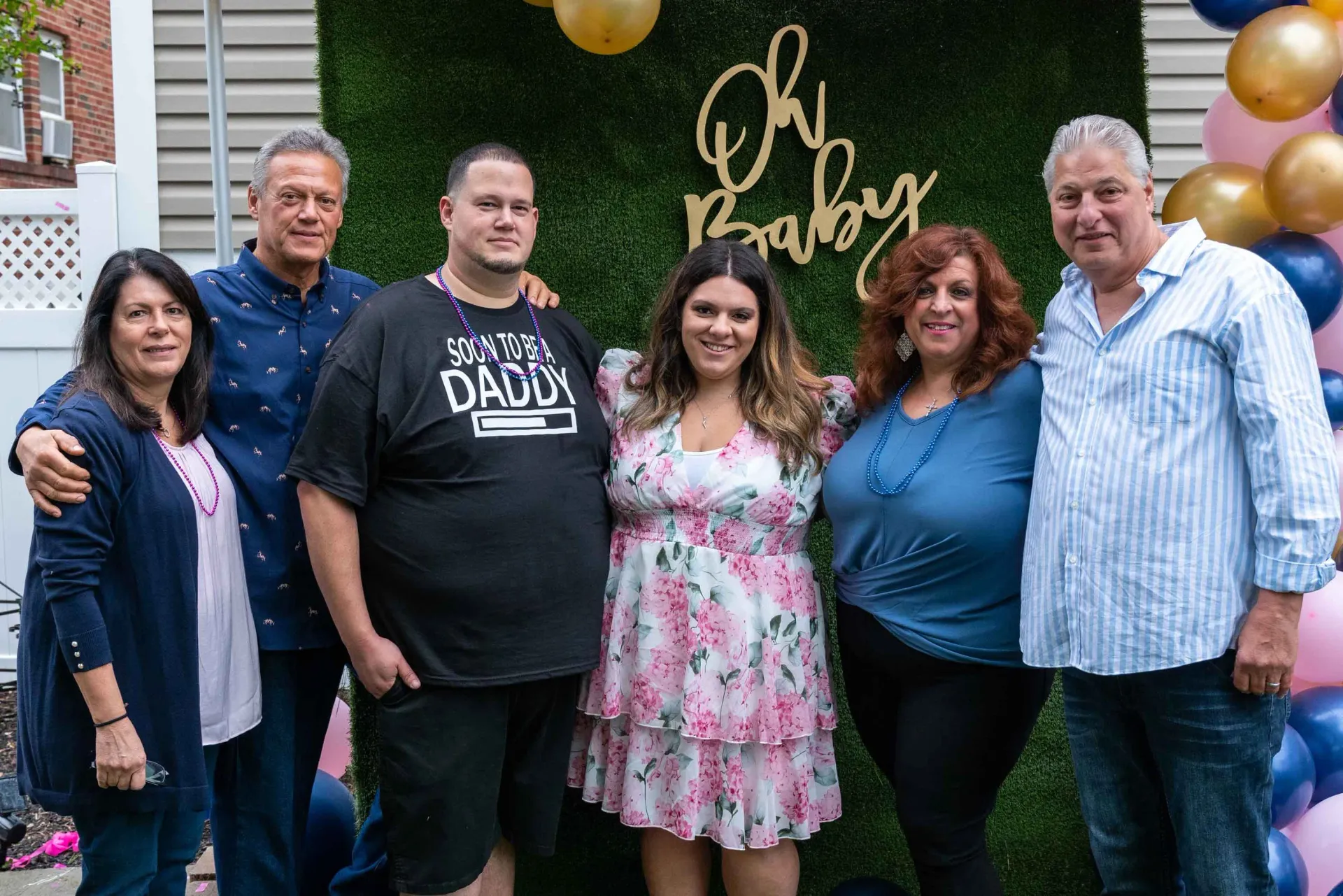 A group of people are posing for a picture at a baby shower.