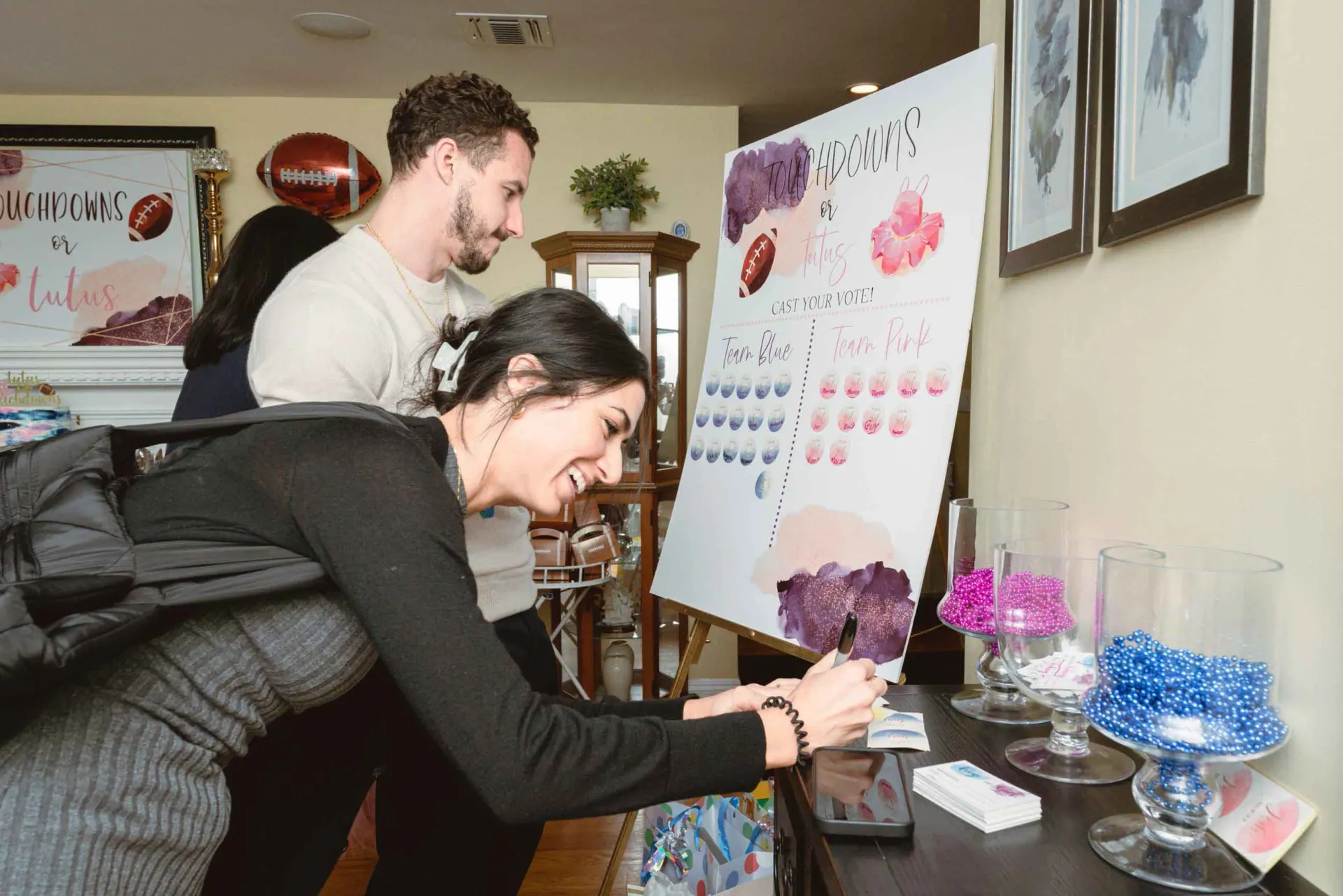 A woman is writing on a white board in a living room.