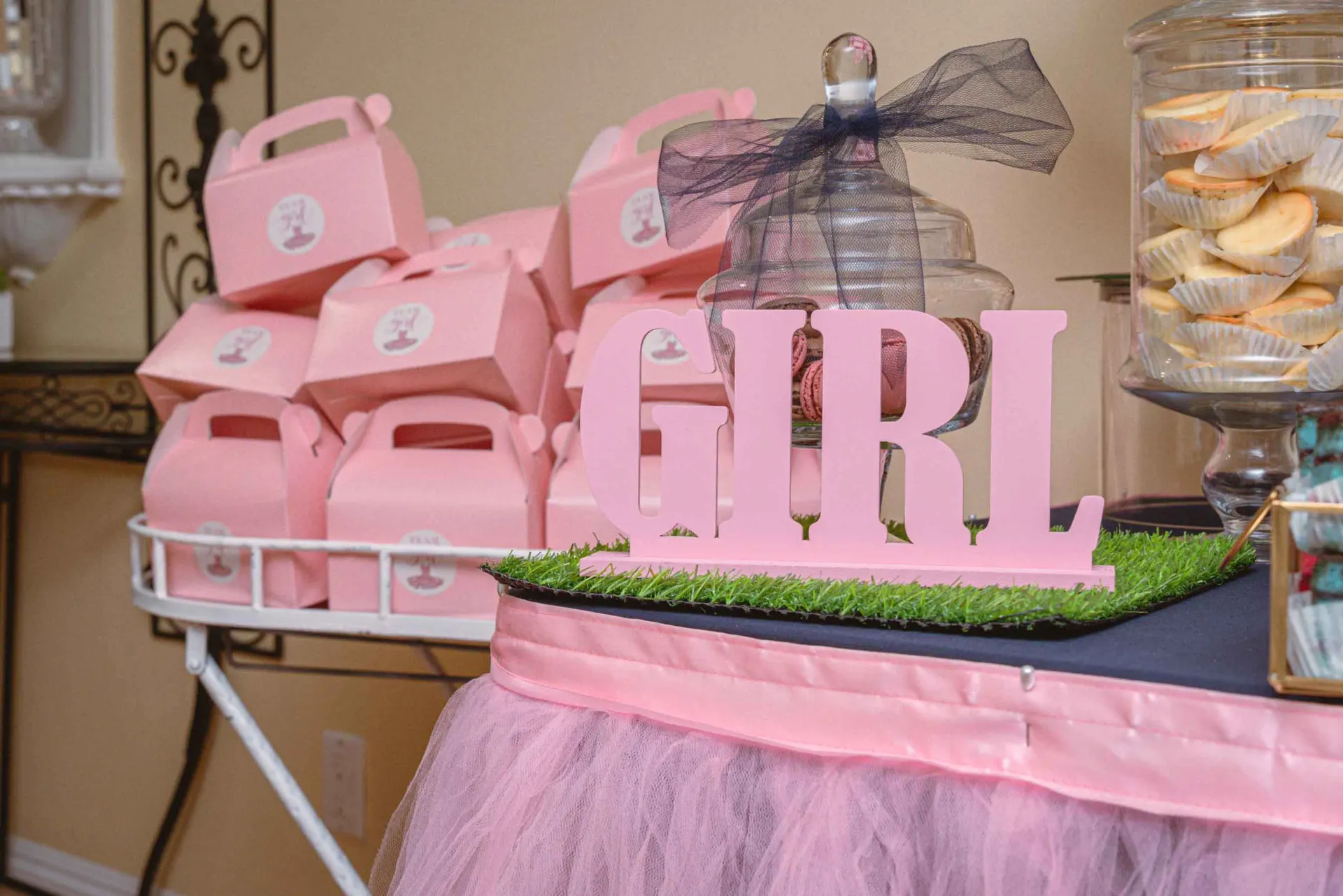 A table with pink boxes and a sign that says girl