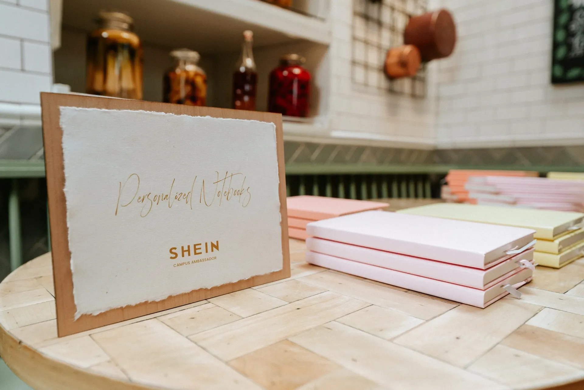 A card is sitting on a wooden table next to a stack of notebooks.